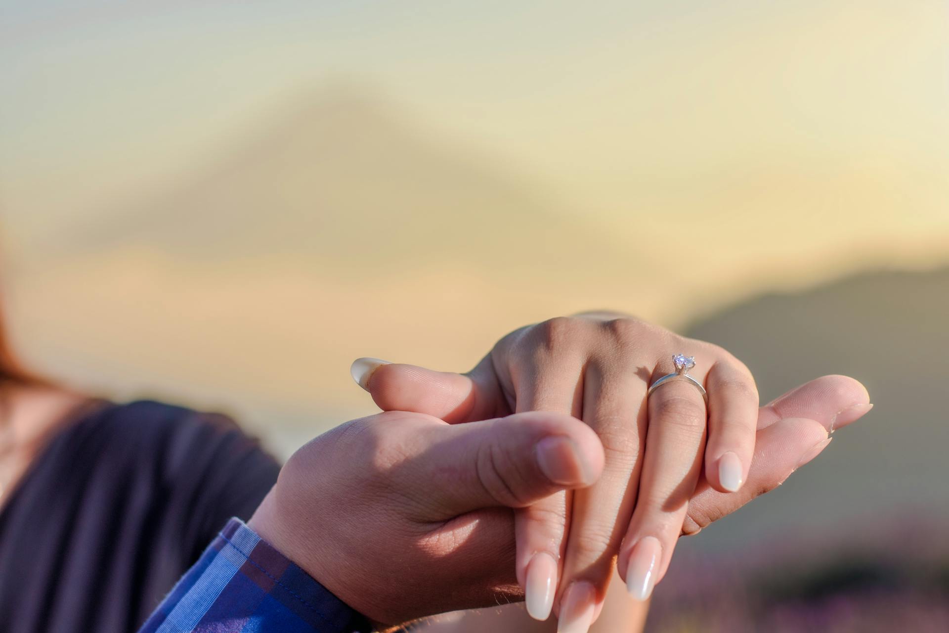 An engaged couple holding hands | Source: Pexels