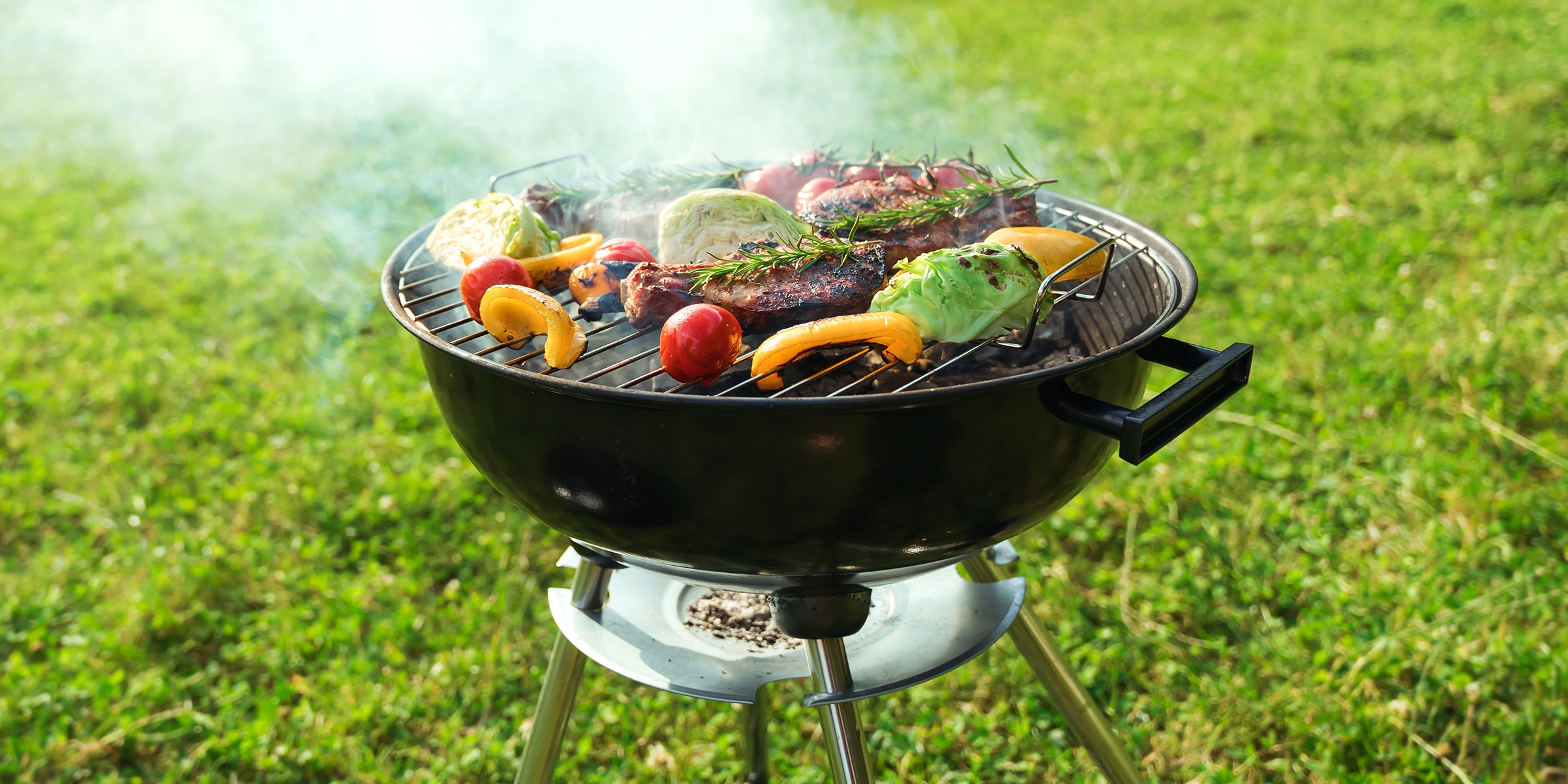 A sizzling backyard barbecue with grilled meat and vegetables on a sunny day | Source: Shutterstock