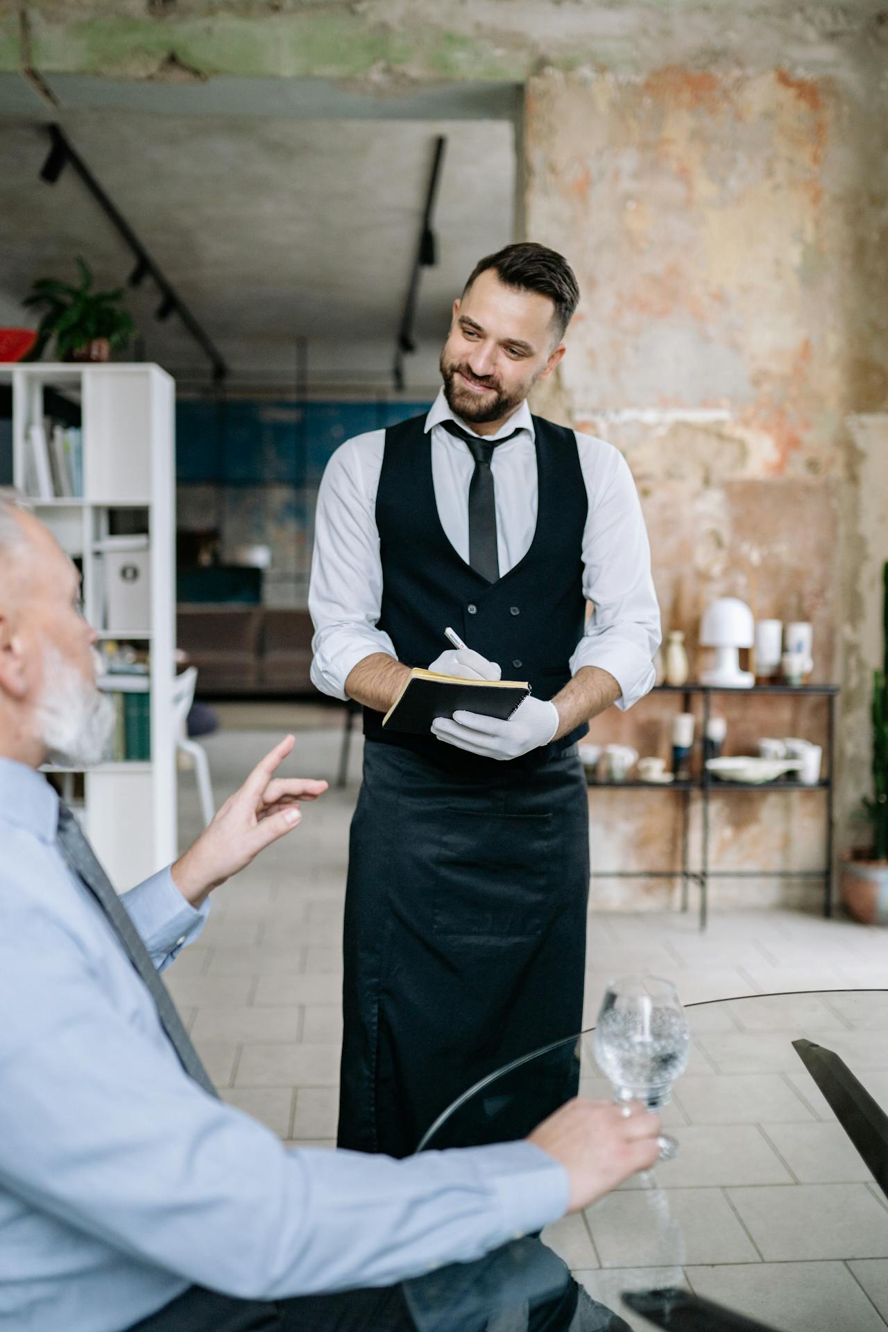 A waiter taking an order from a customer in a restaurant | Source: Pexels