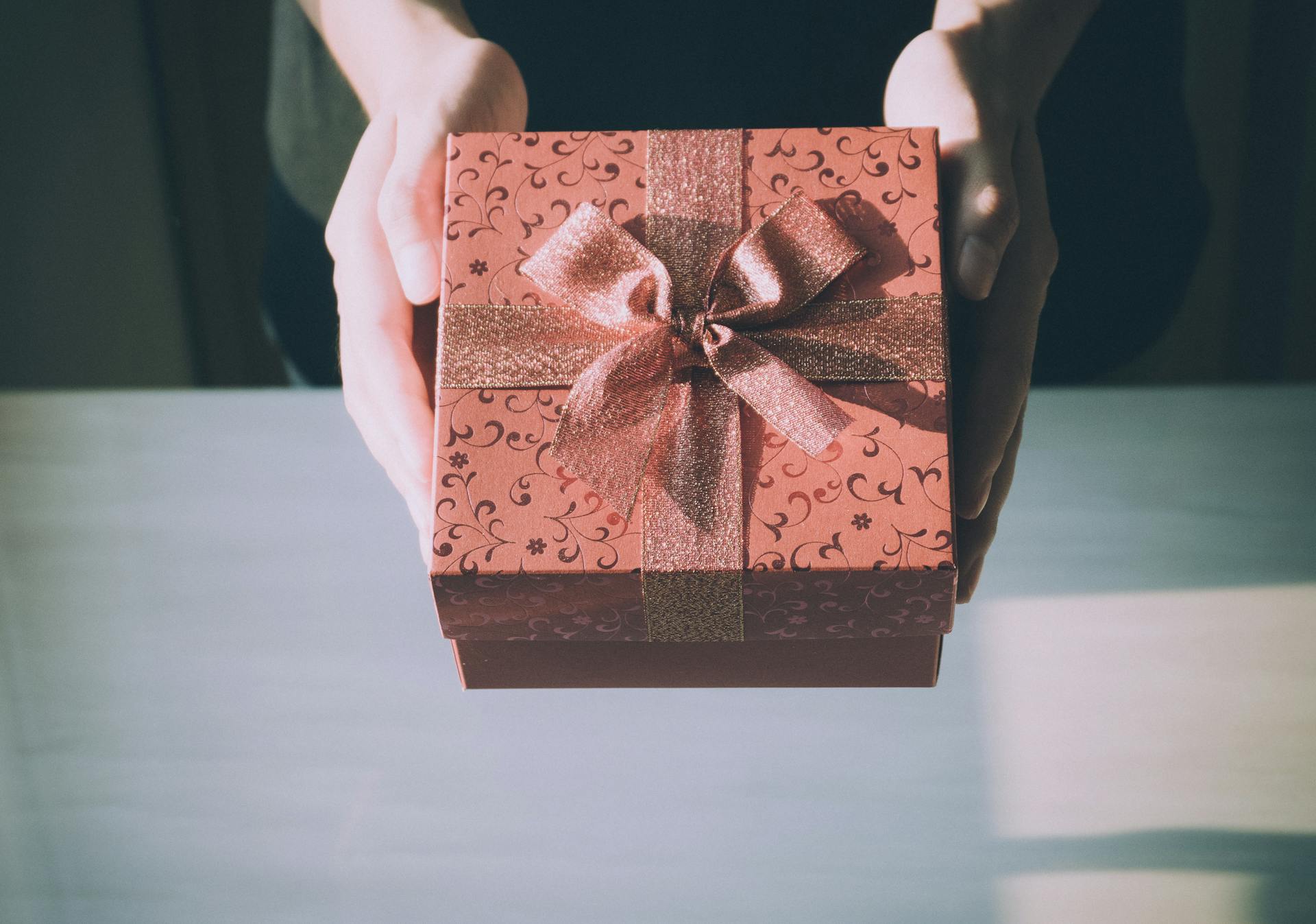 A woman holding a gift box | Source: Pexels