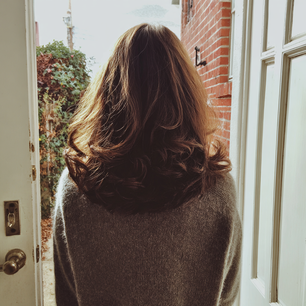 A woman walking out of a home | Source: Midjourney