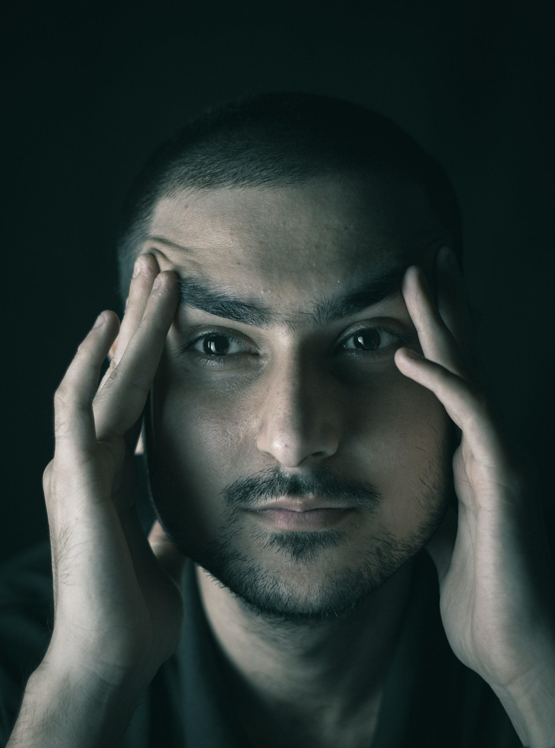 A tense man rubbing his temples | Source: Unsplash