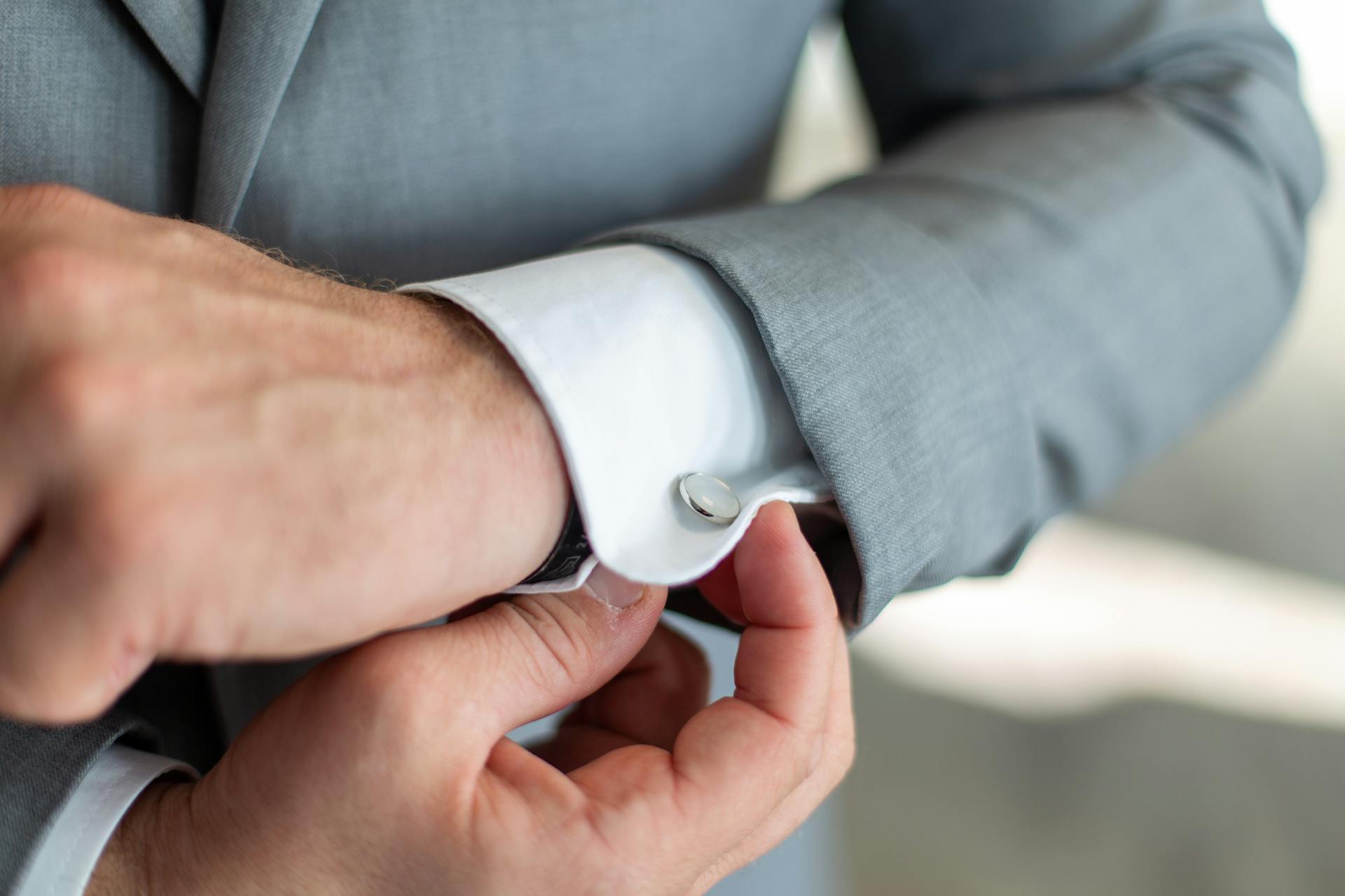 A close-up shot of a man adjusting his cufflink | Source: Pexels