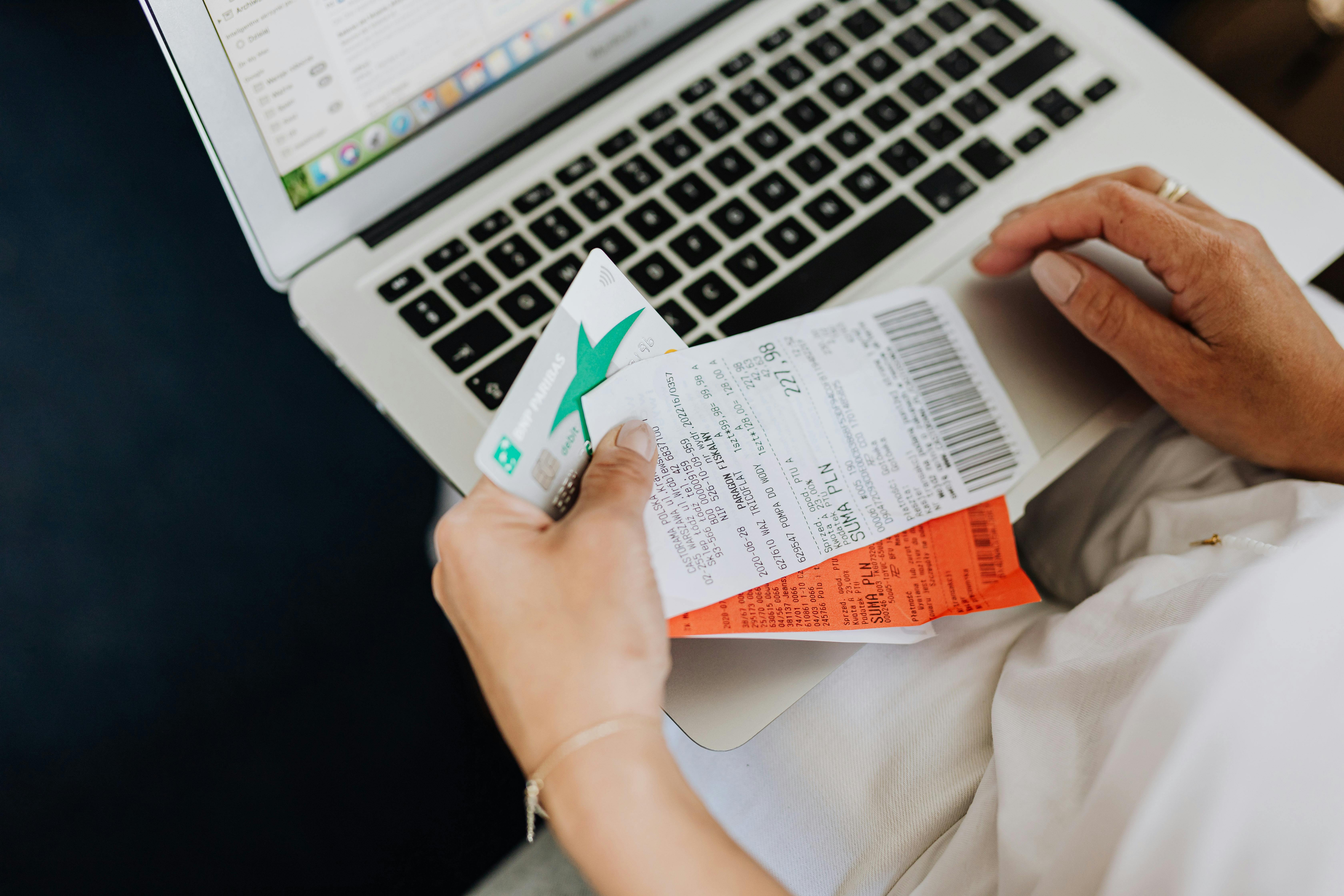 A woman holding a credit card and receipts | Source: Pexels