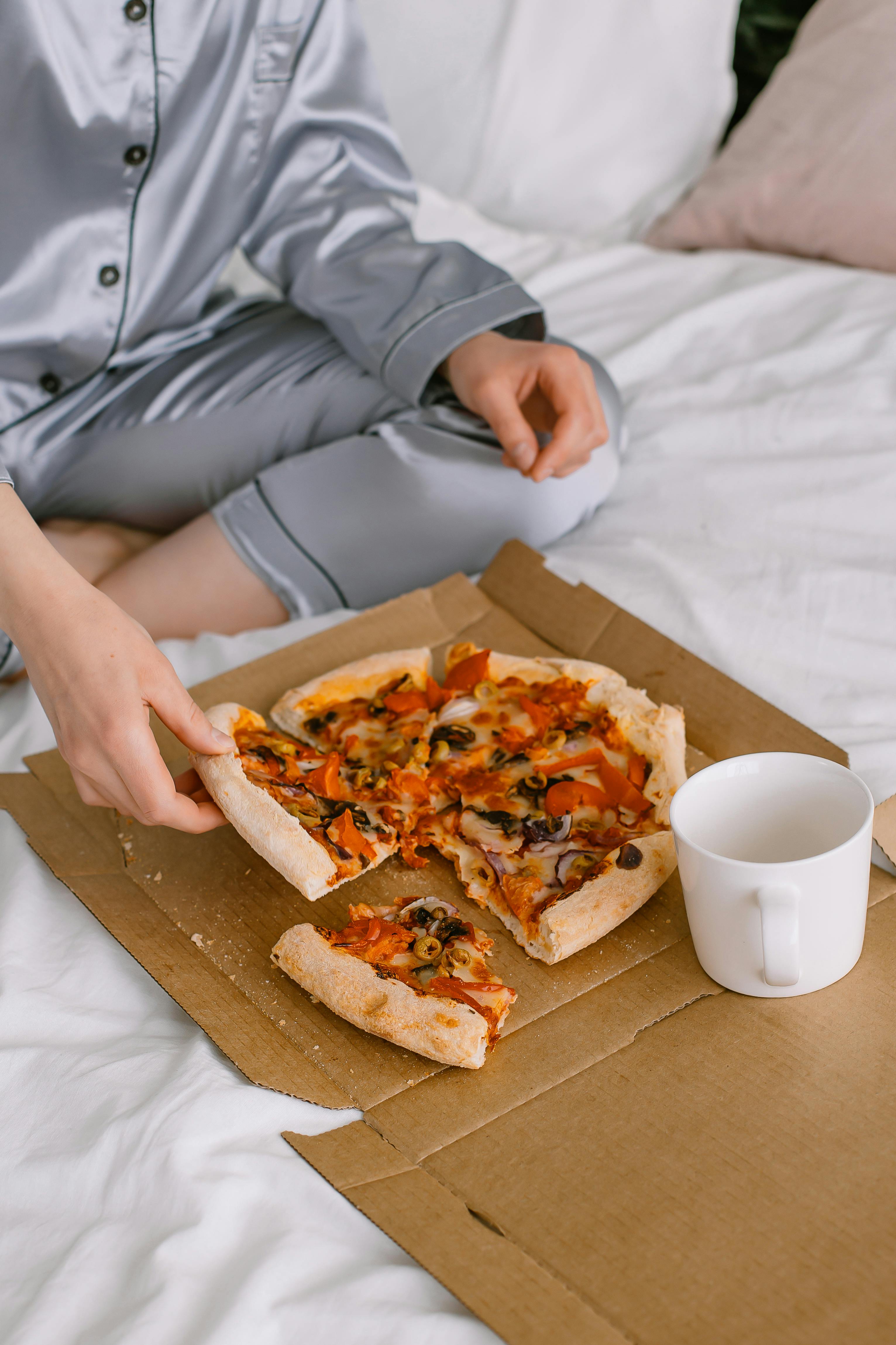 A person eating pizza from a box | Source: Pexels