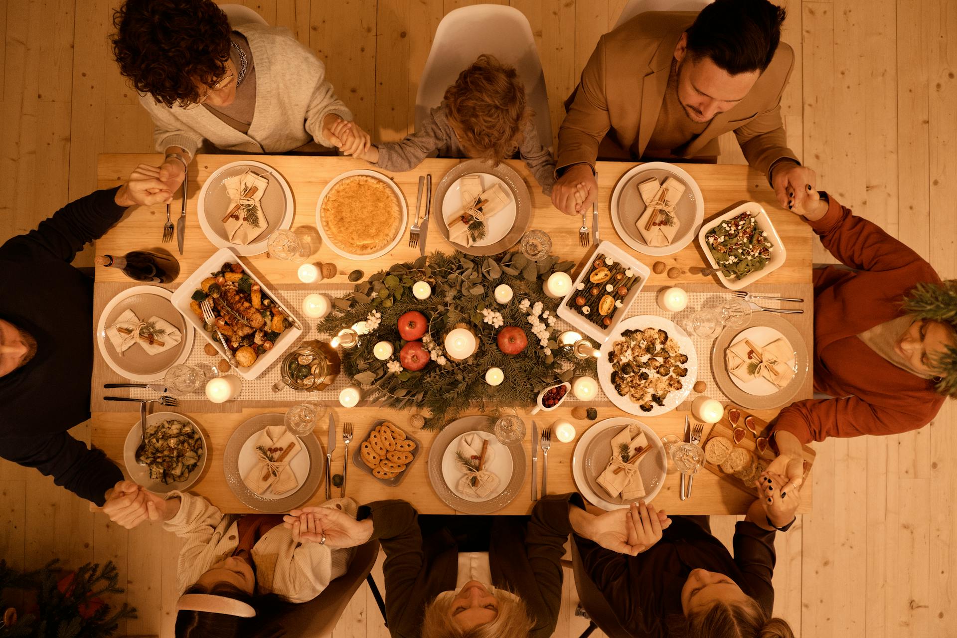 A top view of a family praying before Christmas dinner | Source: Pexels