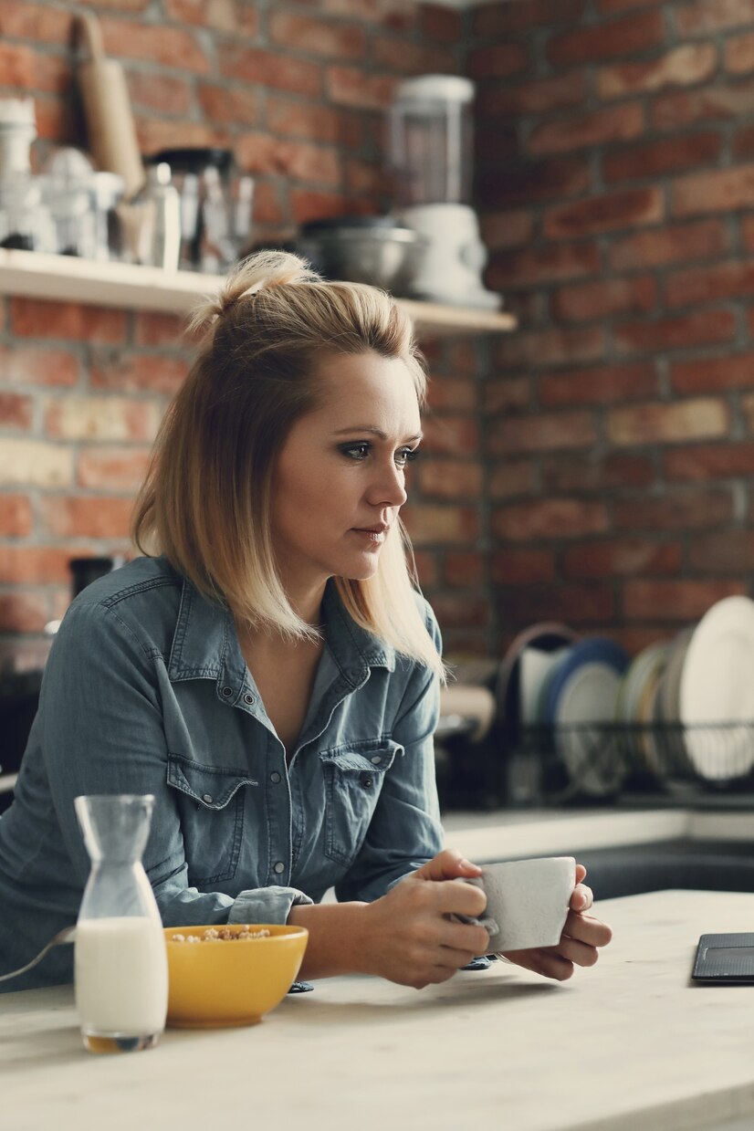 A thoughtful woman drinking coffee | Source: Freepik