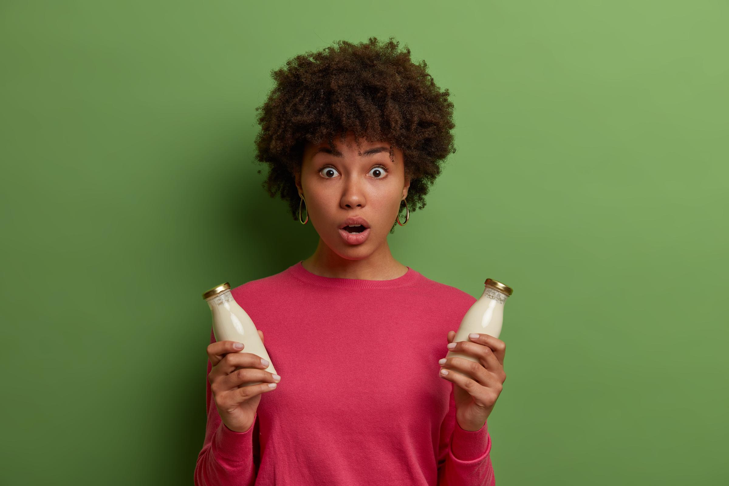 Uma mulher chocada segurando leite | Fonte: Freepik