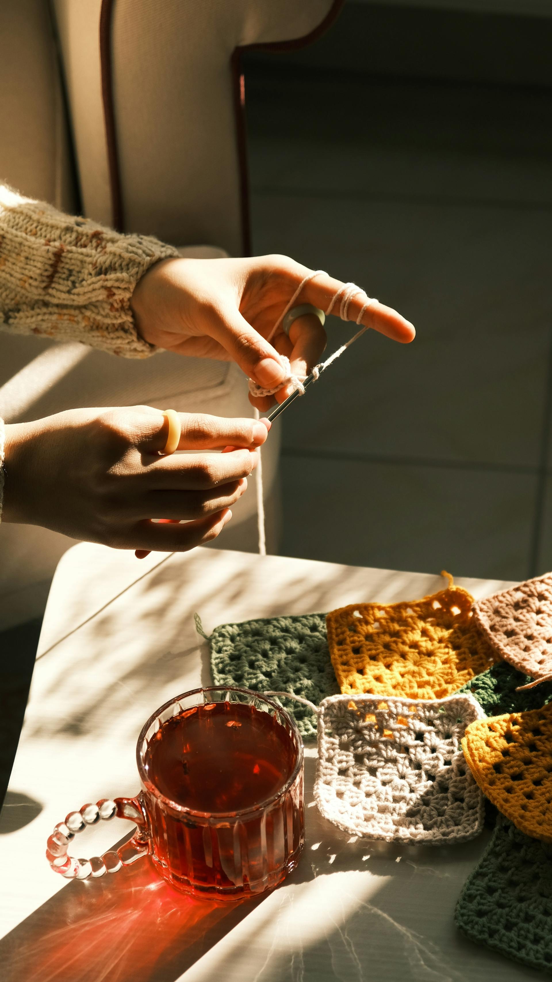 A woman crocheting a granny square | Source: Pexels
