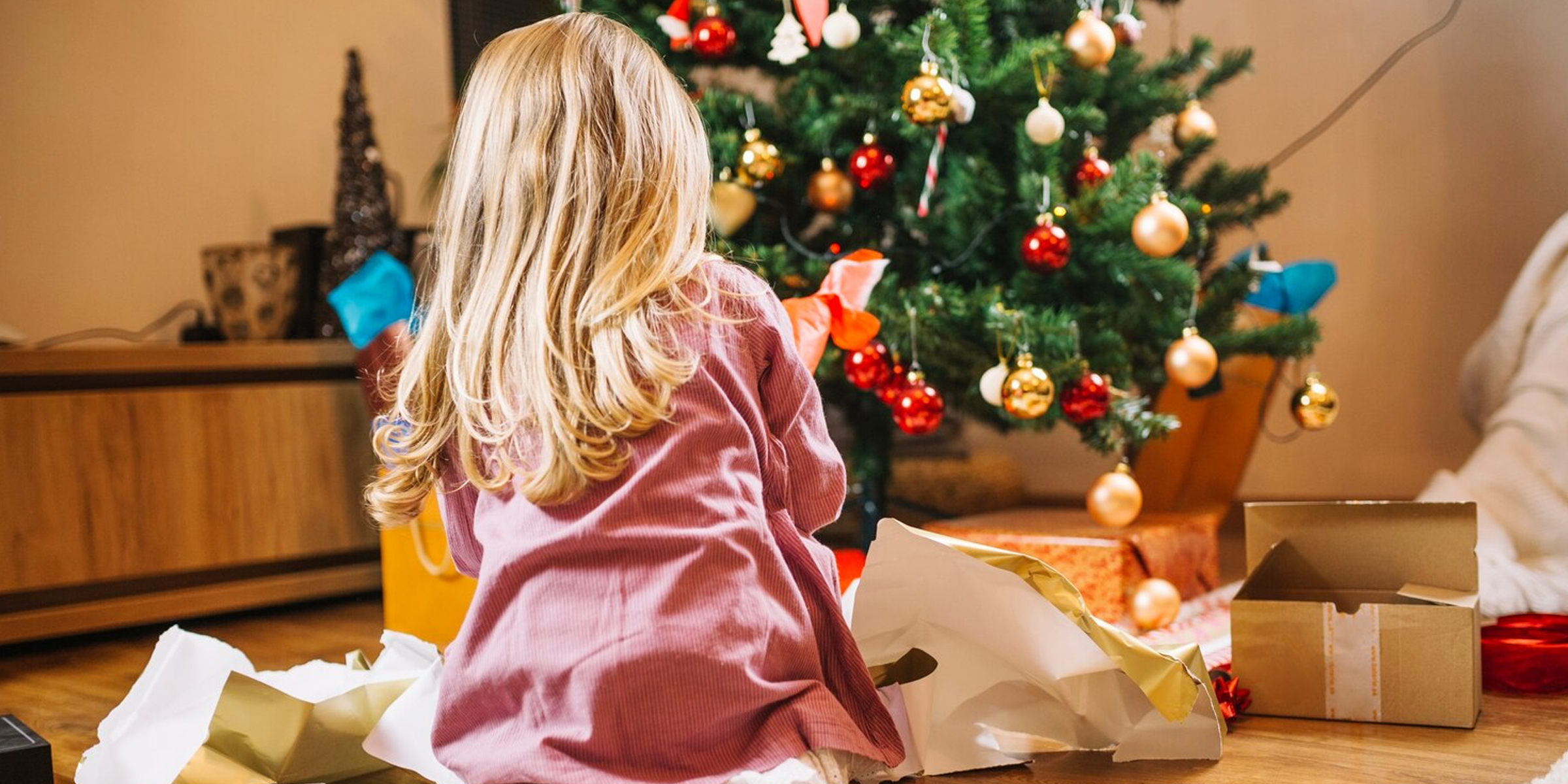 A girl opening Christmas gifts | Source: FreePik