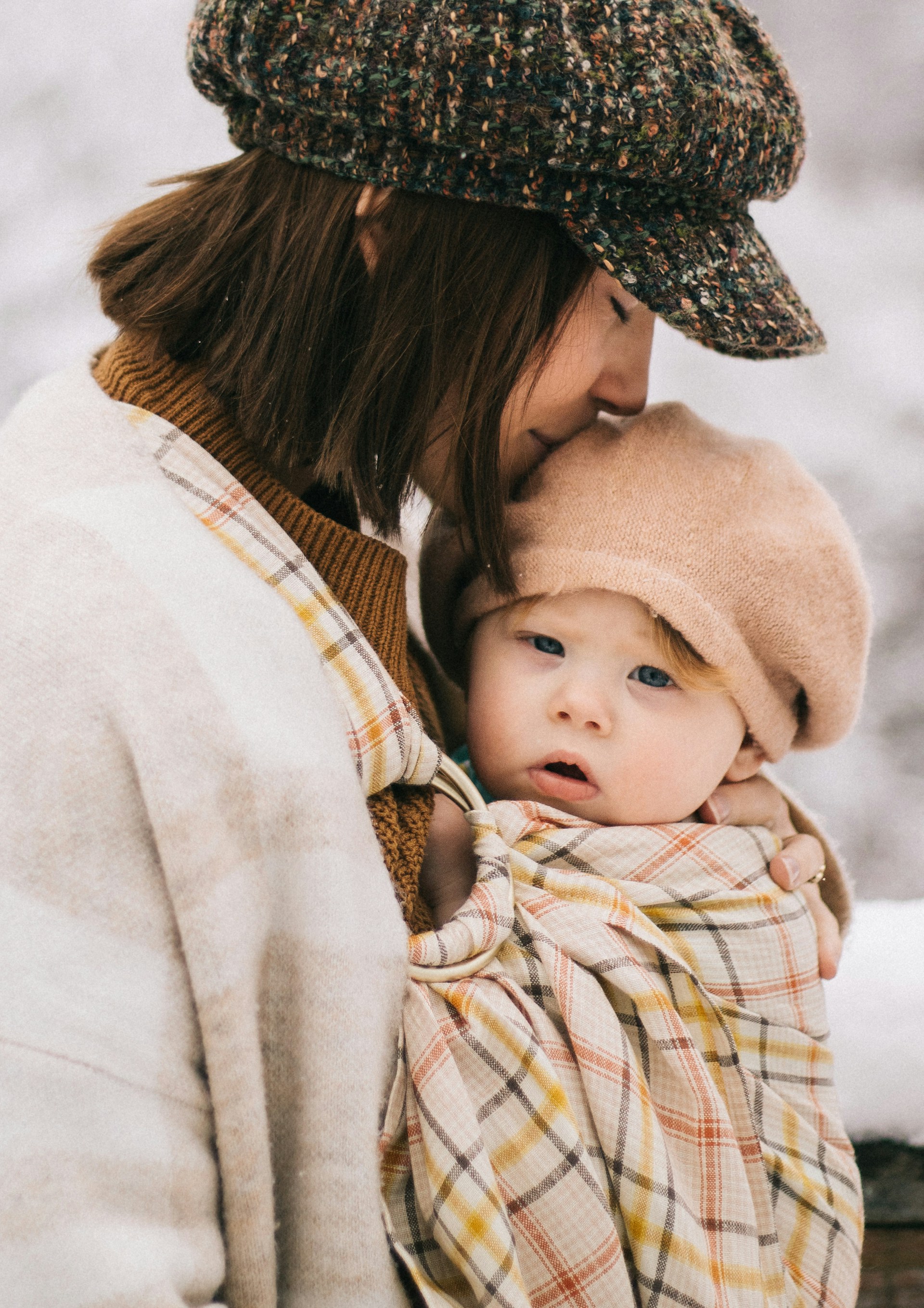 A woman gently kissing her child, depicting a mother's unconditional love | Source: Unsplash