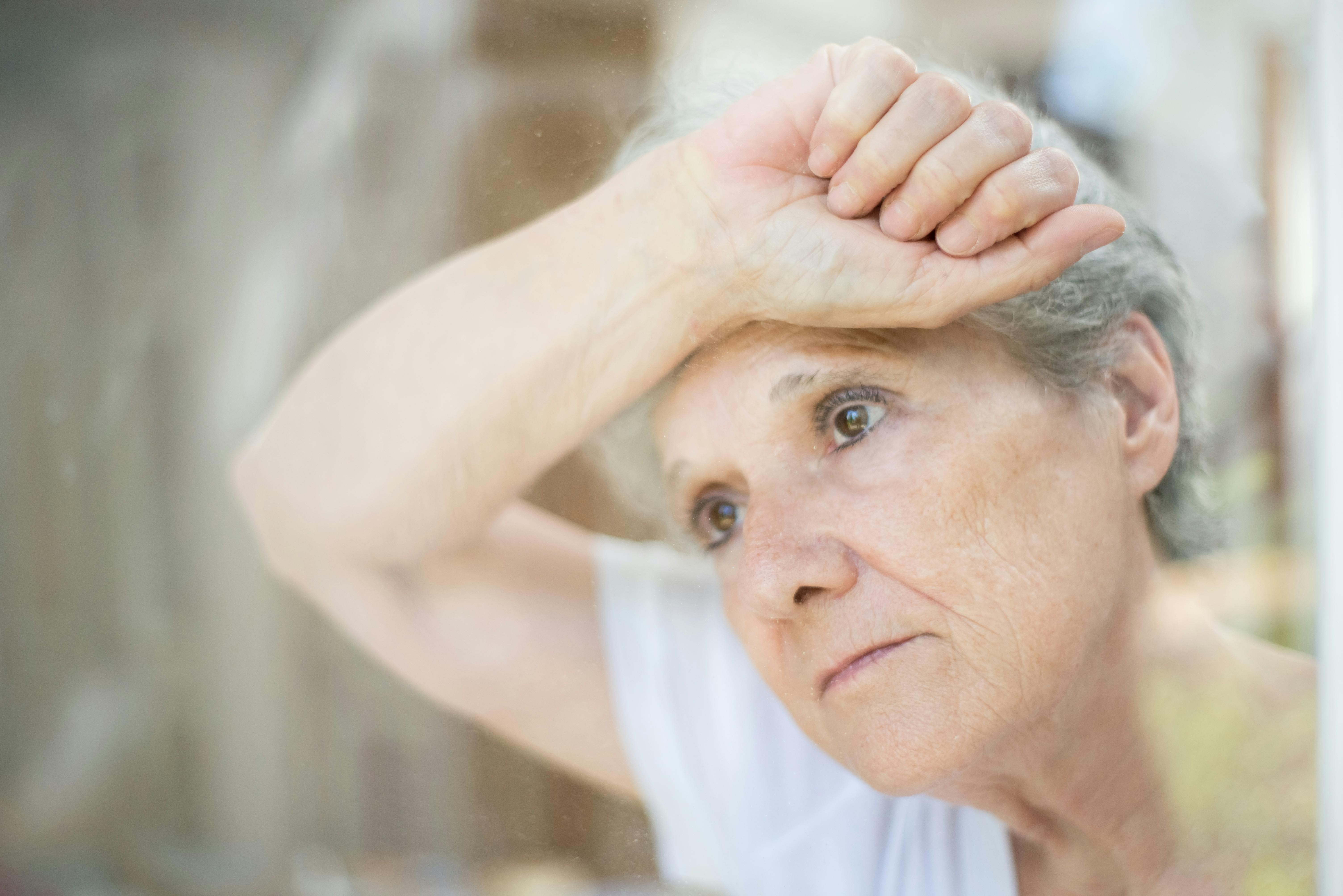 A close-up of an old woman leaning on glass | Source: Pexels