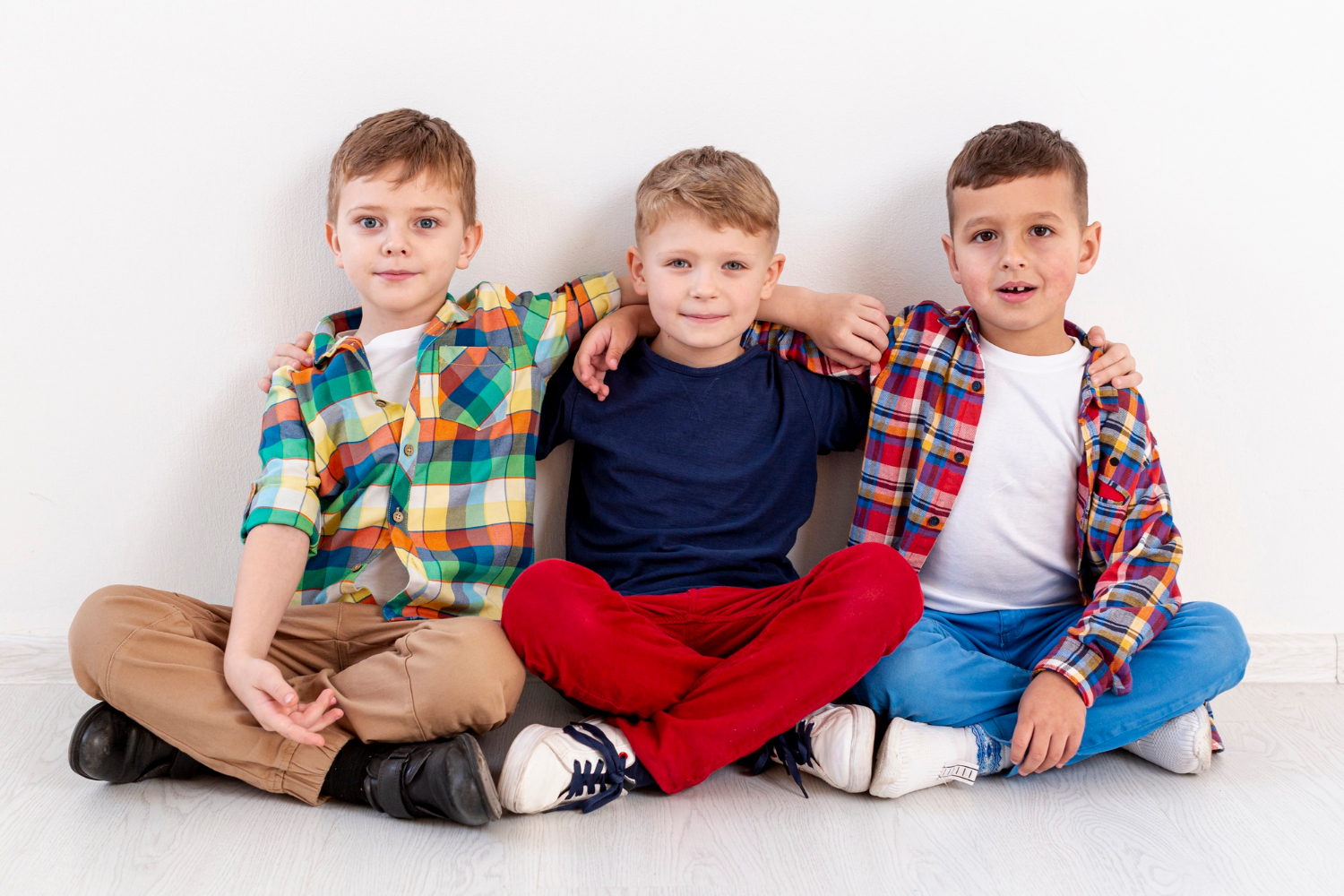 Three young boys sitting together | Source: Freepik