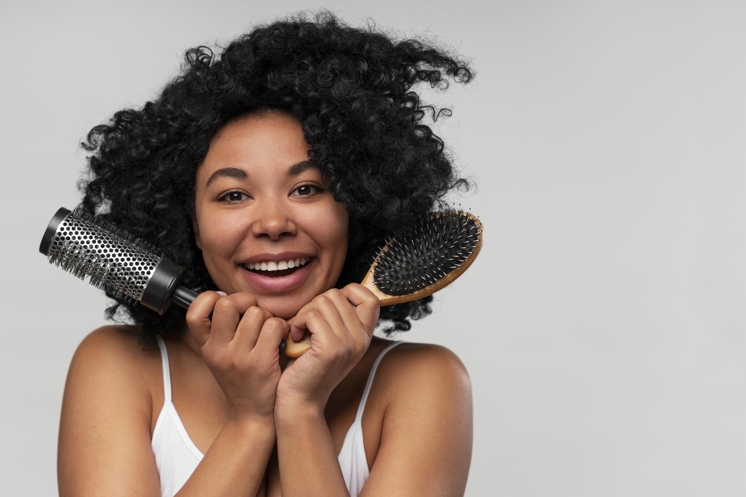 A happy woman with hairbrushes | Source: Freepik