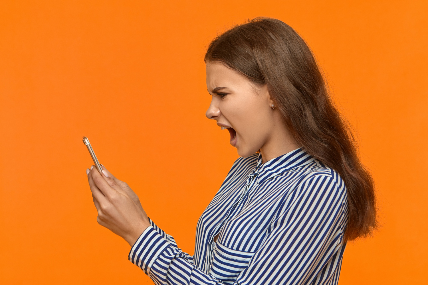 A furious woman looking at her phone and yelling | Source: Freepik