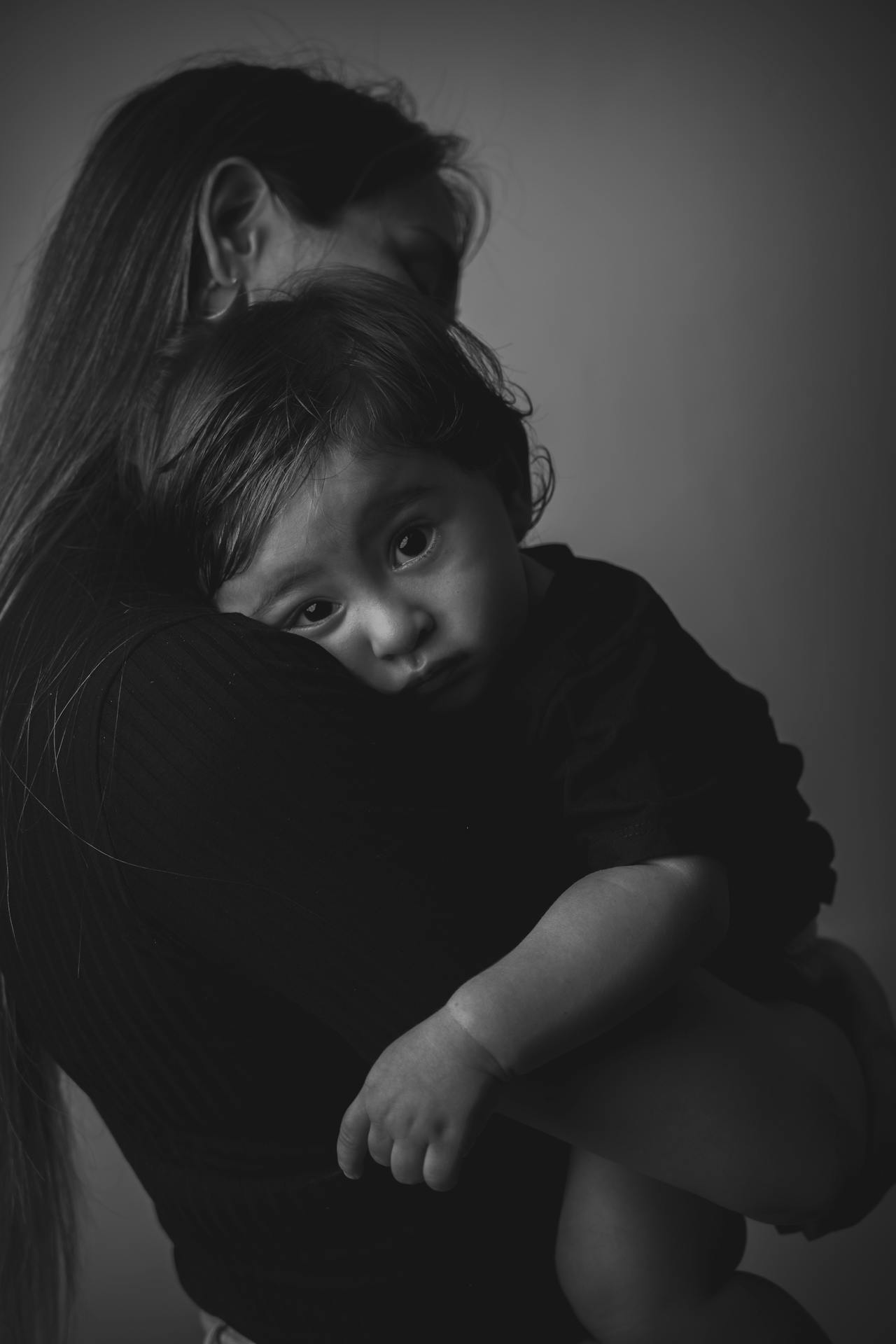 Grayscale shot of a mother holding her child | Source: Pexels