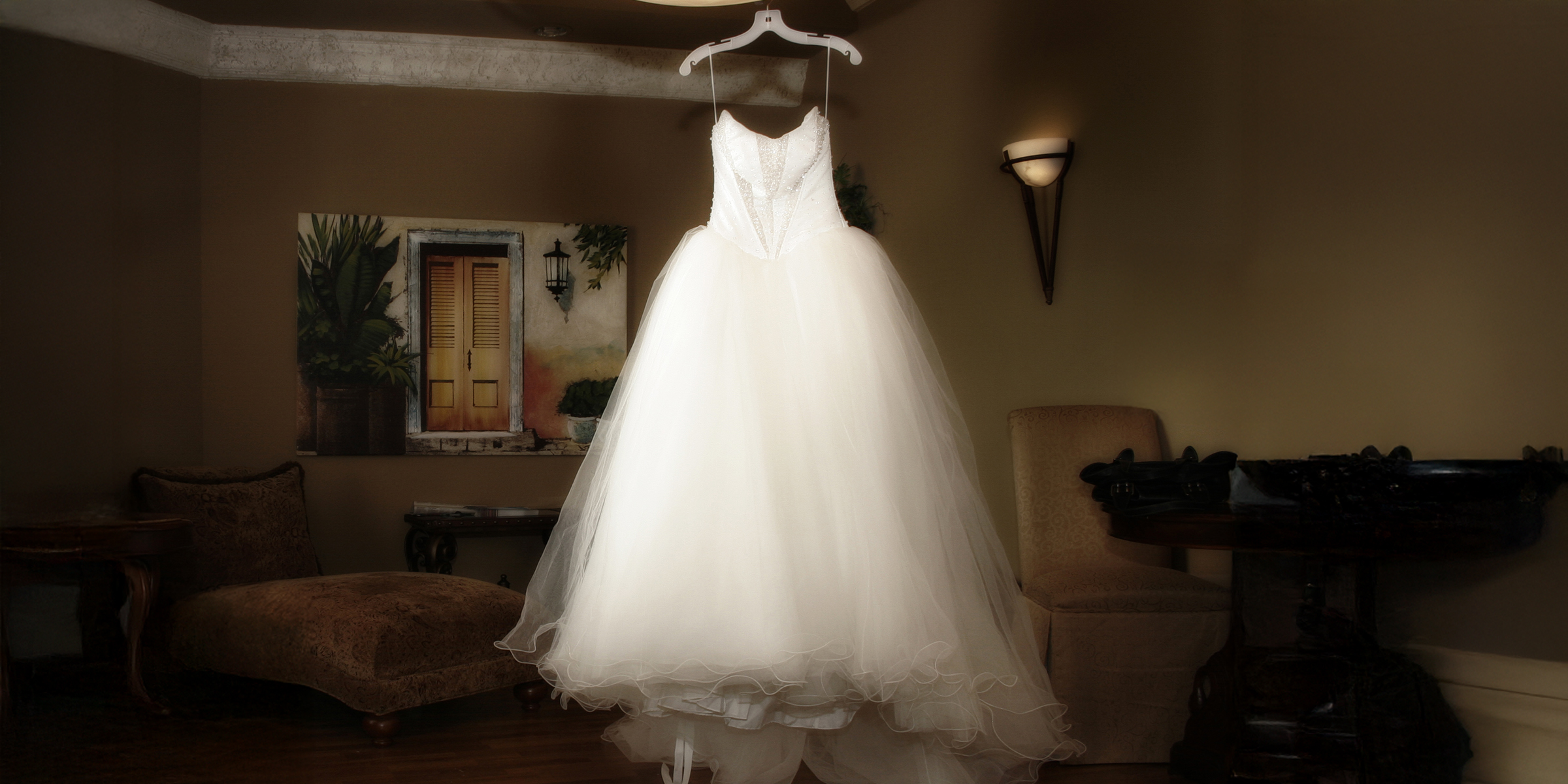 An elegant white wedding gown suspended on a hanger | Source: Shutterstock