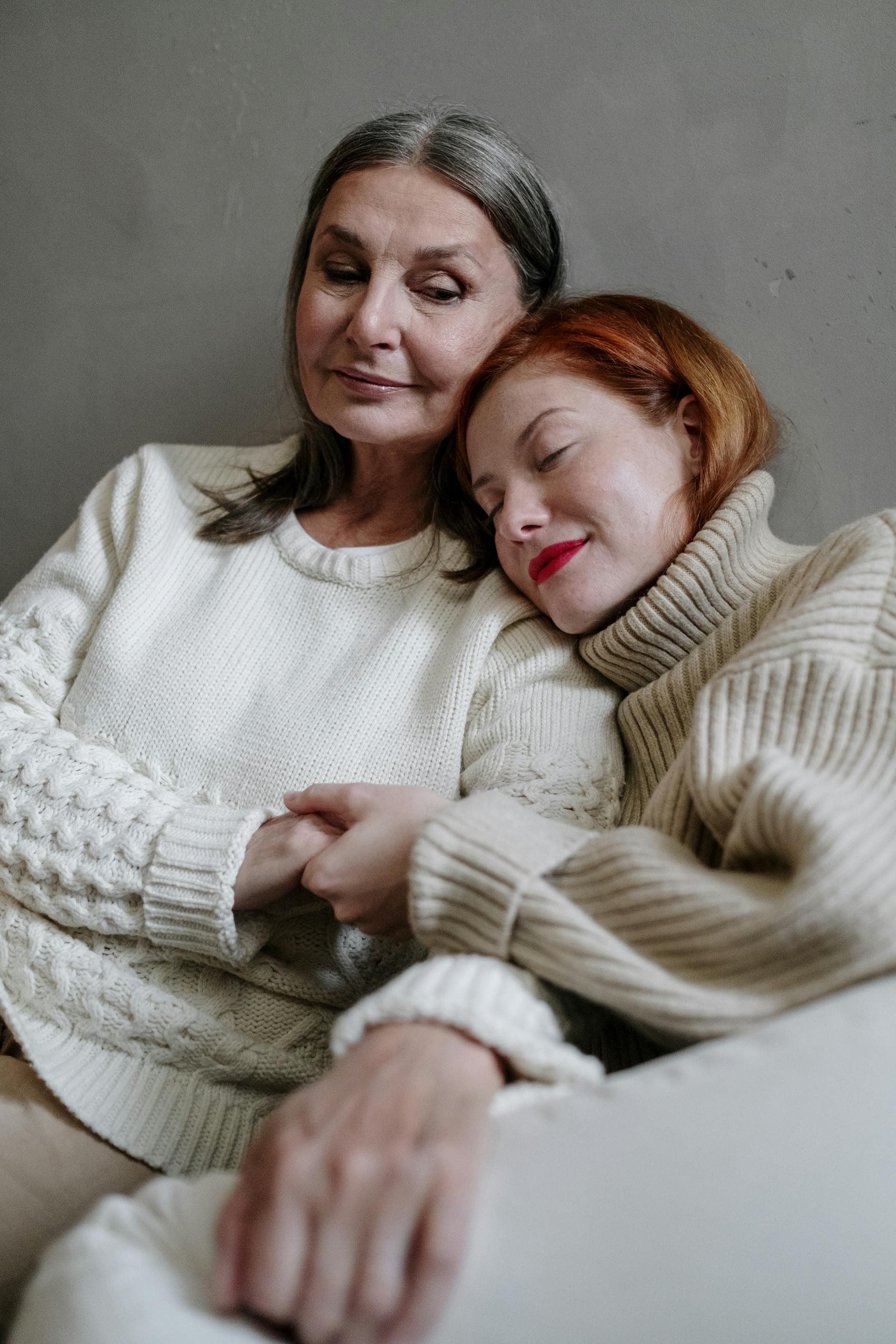 A young woman resting her head on a senior woman's shoulder | Source: Pexels