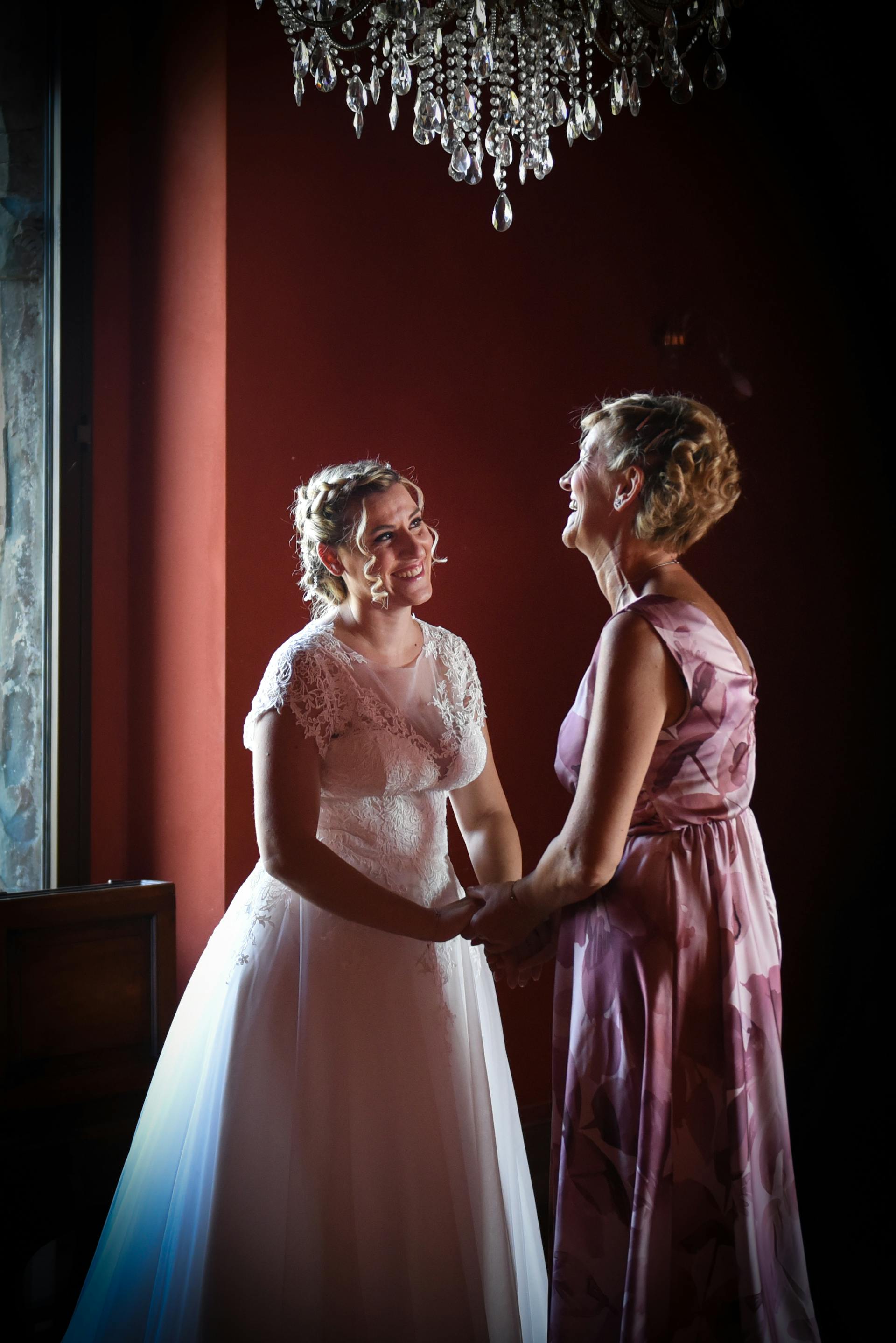 A bride holding a senior woman's hand and smiling | Source: Pexels