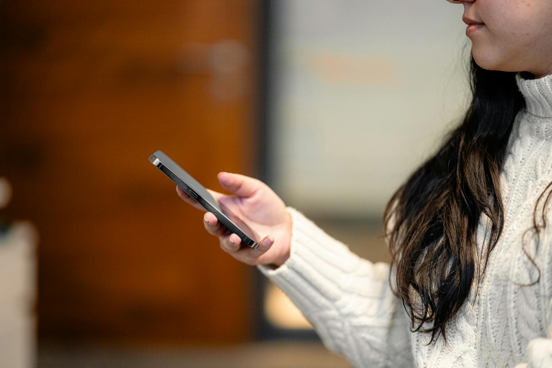 A woman holding her cell phone | Source: Pexels