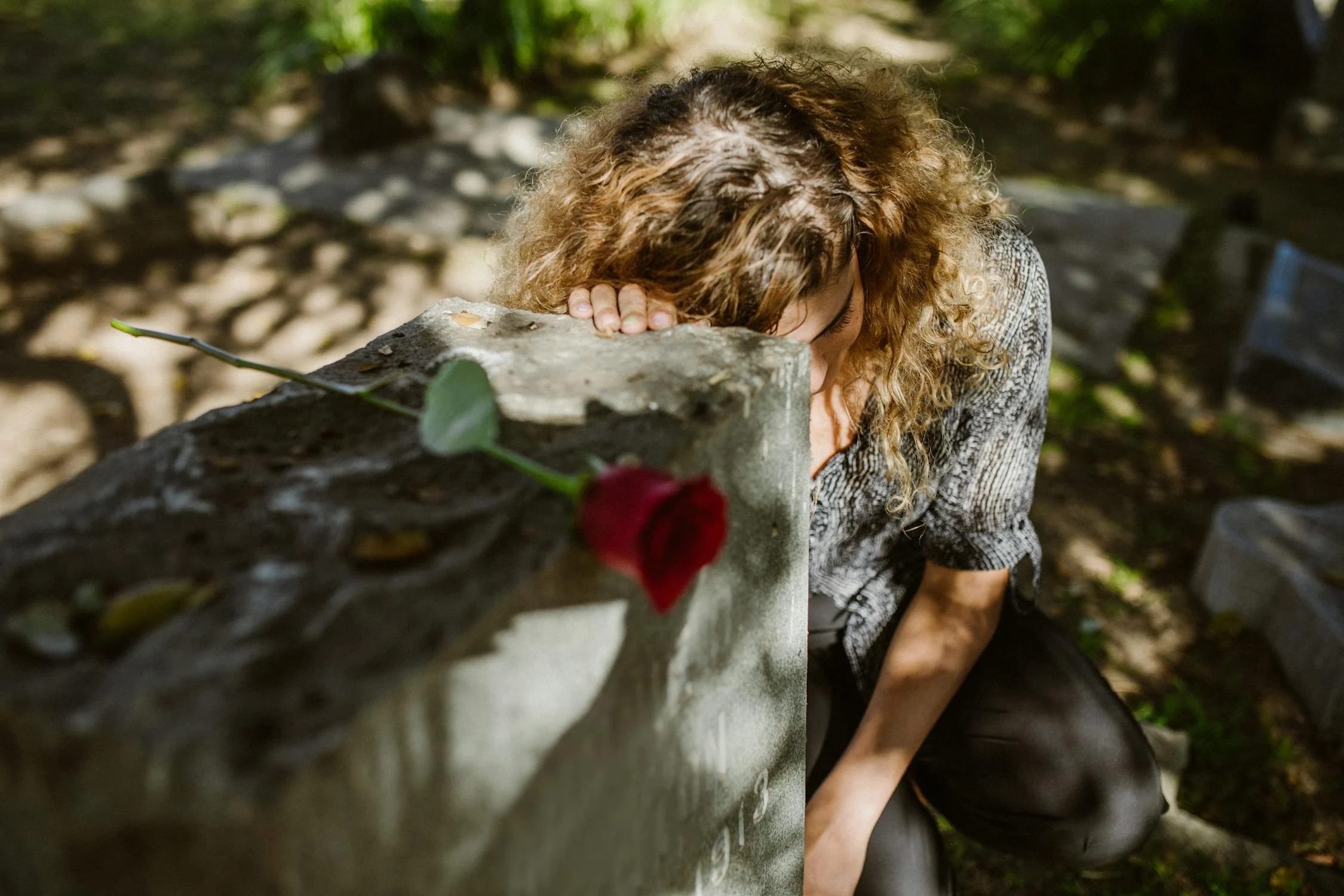 A grieving woman and a rose | Source: Pexels