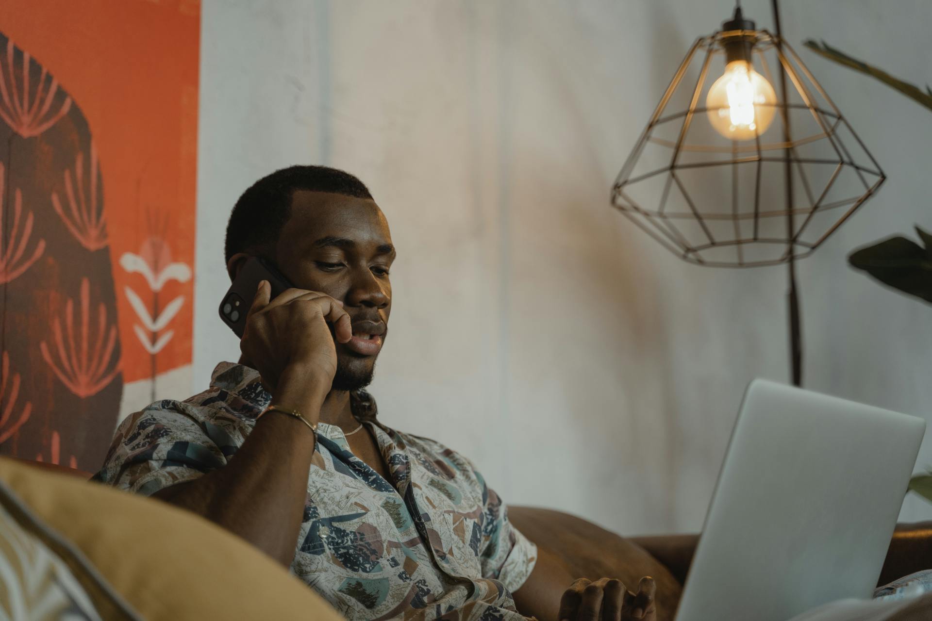 A man staring at his laptop while talking on the phone | Source: Pexels