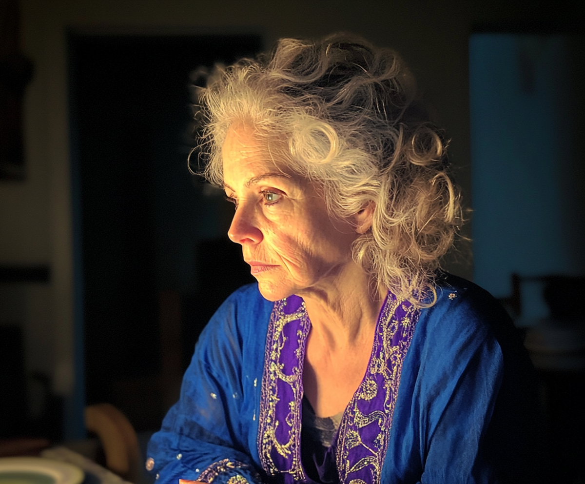 A pensive woman sitting at a table | Source: Midjourney