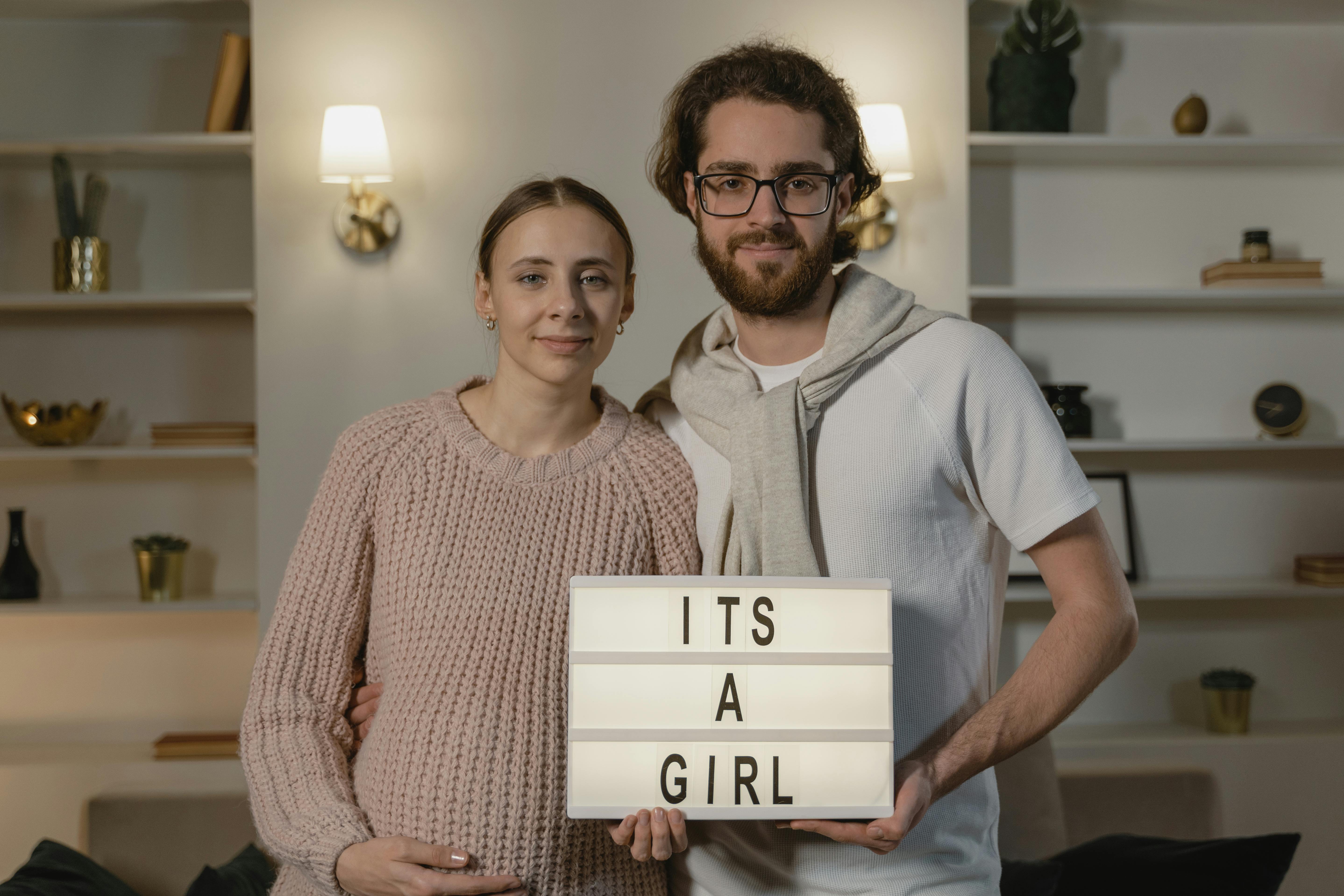 A couple holding a letterboard with a message | Source: Pexels