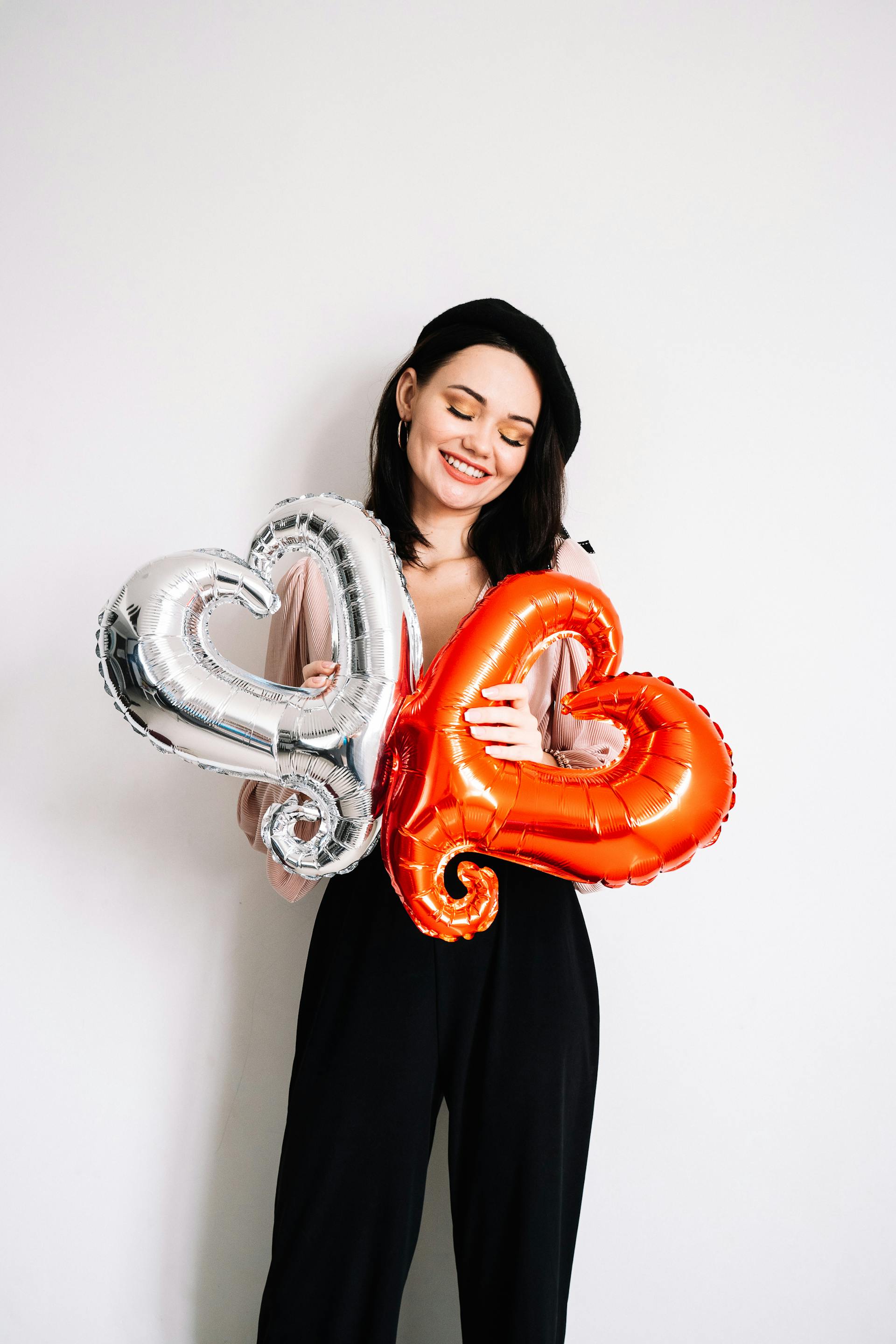 A woman holding heart-shaped balloons | Source: Pexels