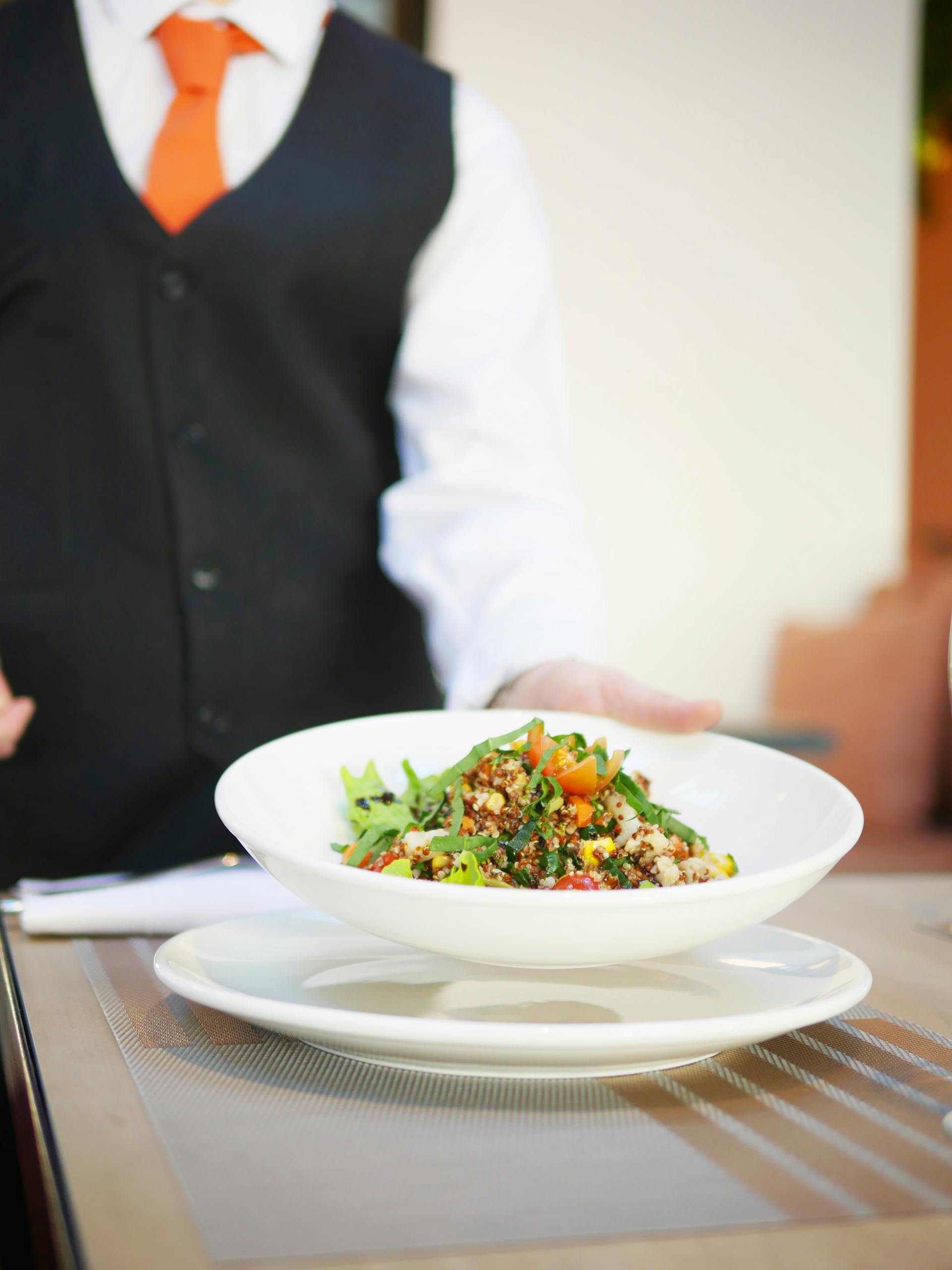 A waiter delivering food in a restaurant | Source: Pexels