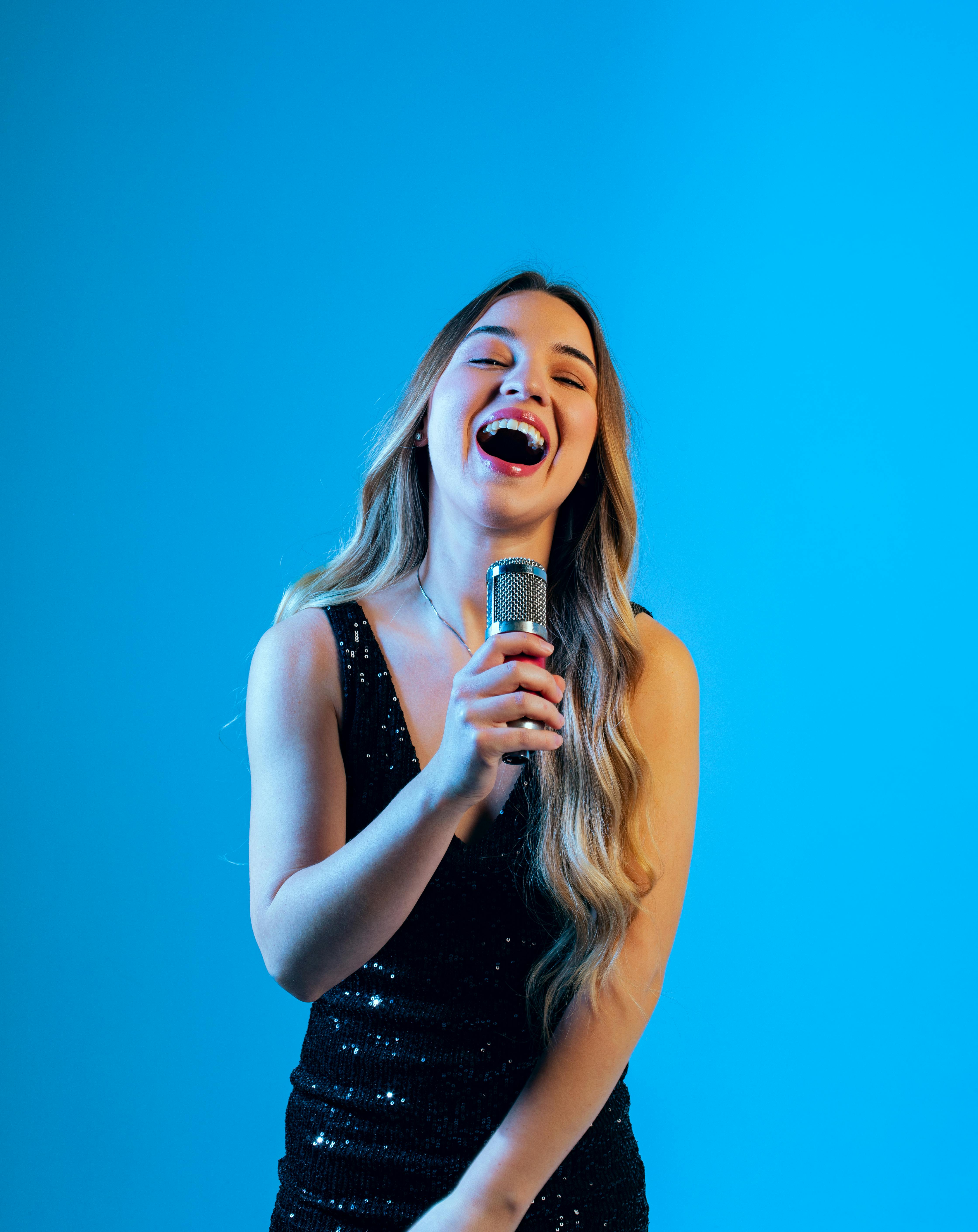 A woman laughing while speaking on a stage | Source: Pexels