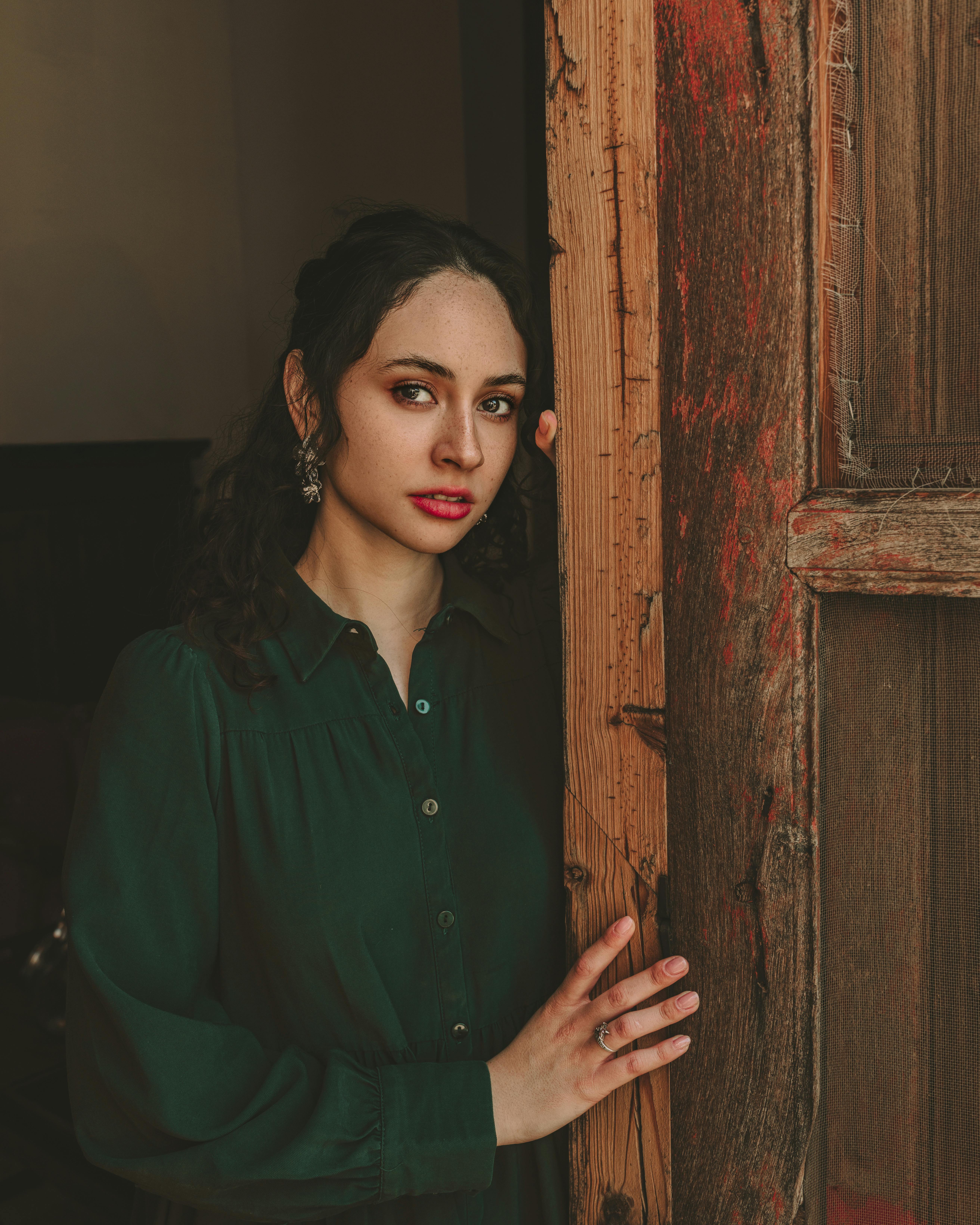A woman holding and leaning on a doorframe | Source: Pexels