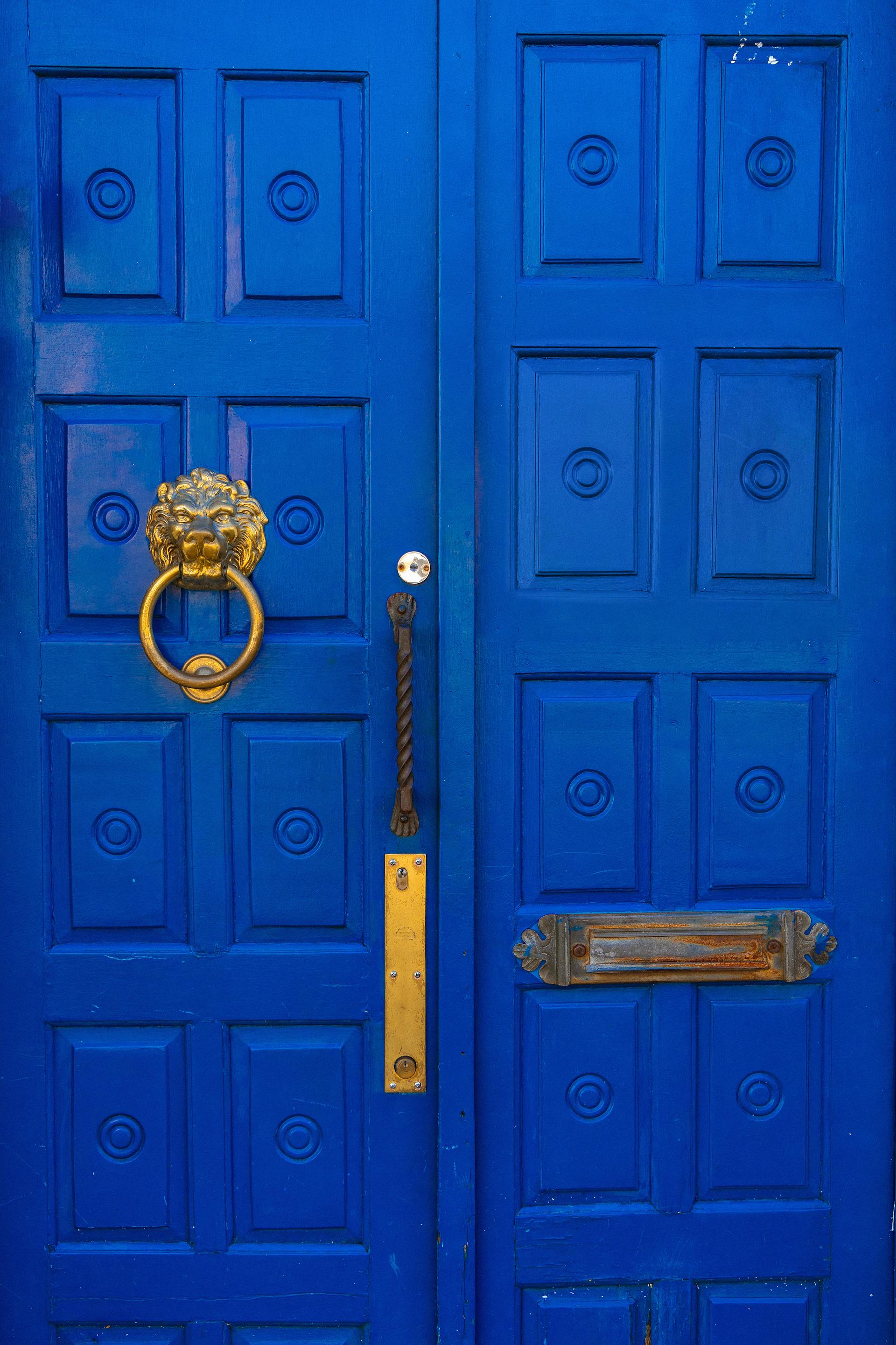 A blue front door with a golden handle | Source: Pexels