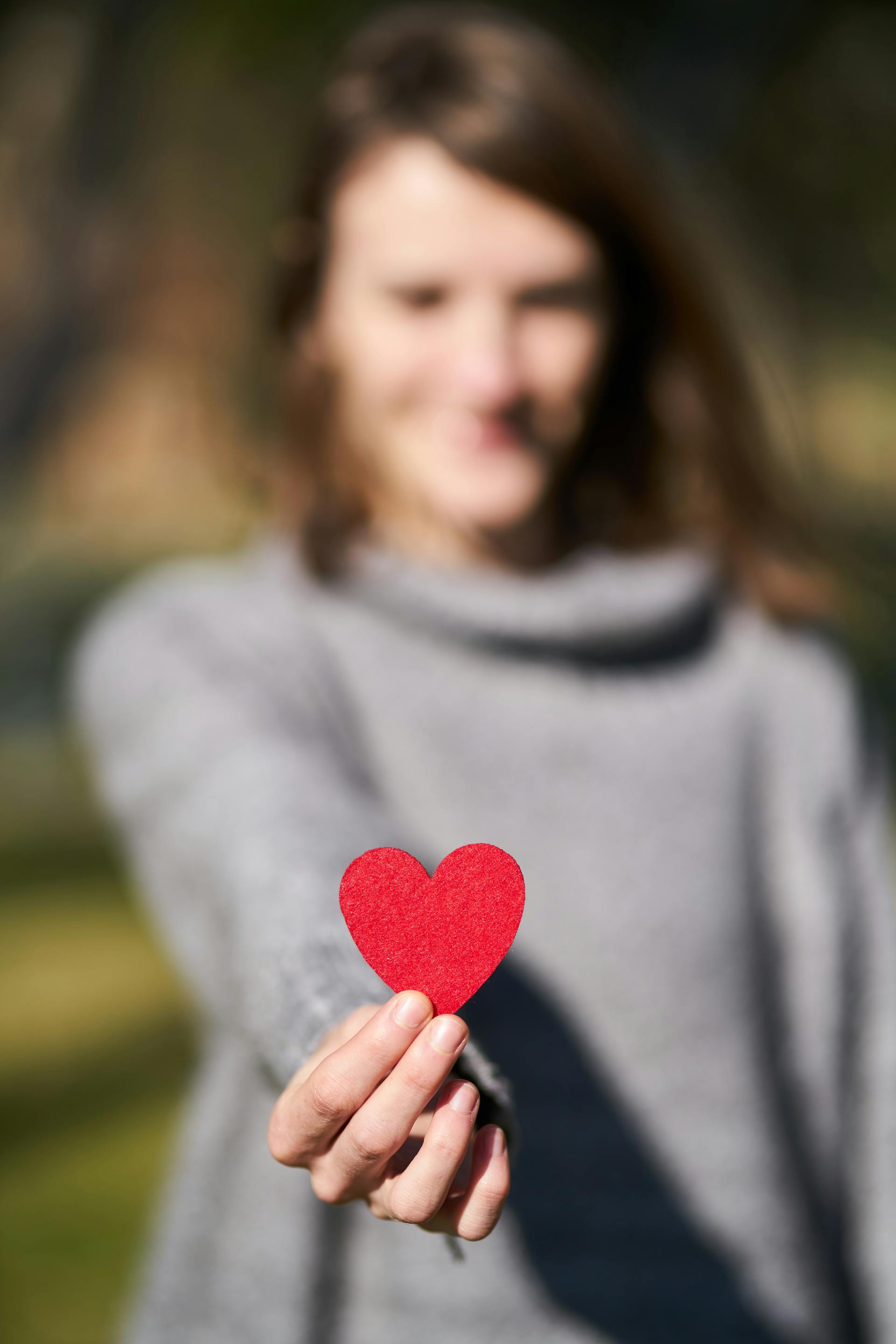 A woman holding a heart-shaped cutout | Source: Pexels