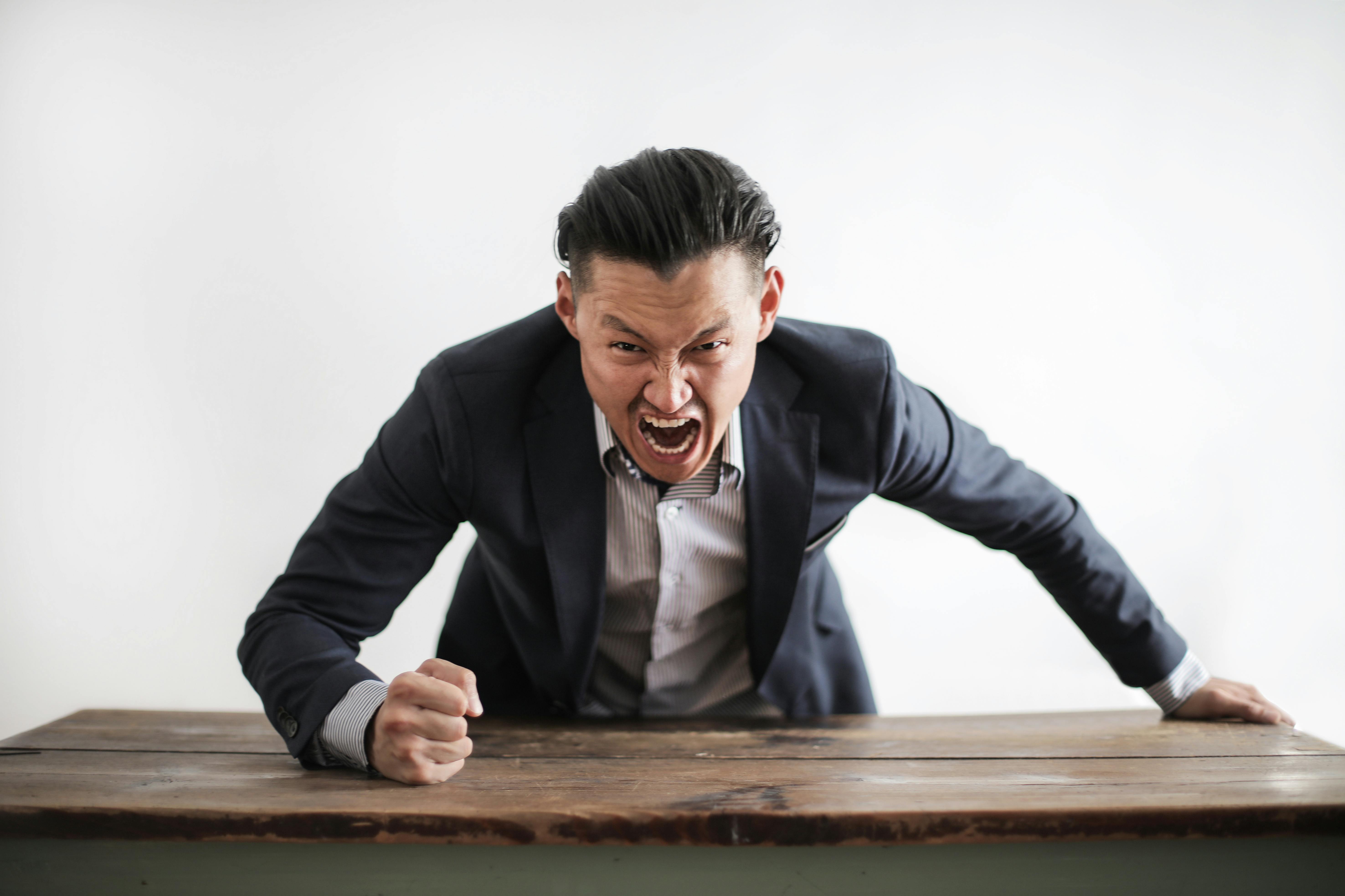An angry man slamming his fist on a table | Source: Pexels