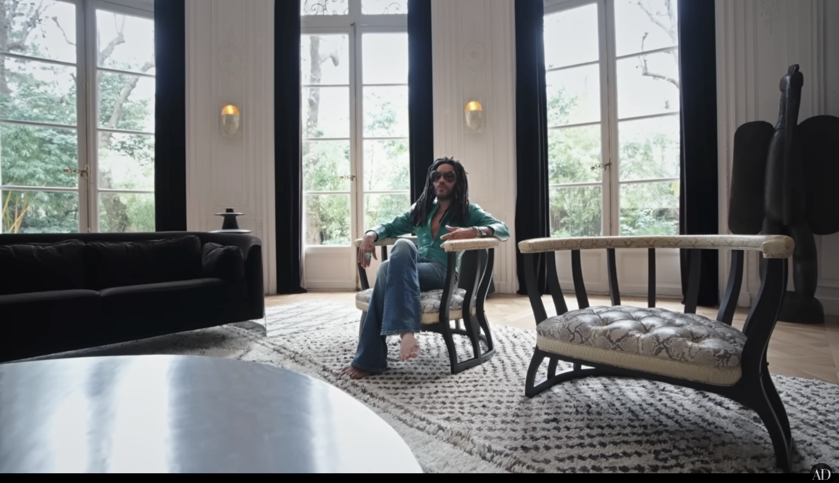 Lenny Kravitz lounging on one of his chairs, posted on April 15, 2025. | Source: YouTube/Architectural Digest