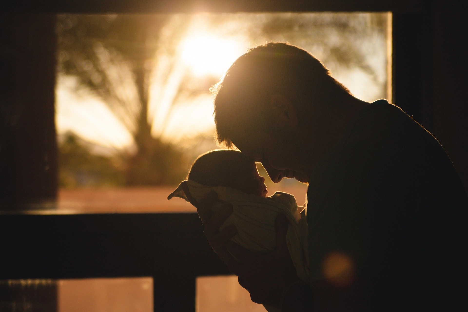 Nostalgic picture of a man holding a baby | Source: Pixabay