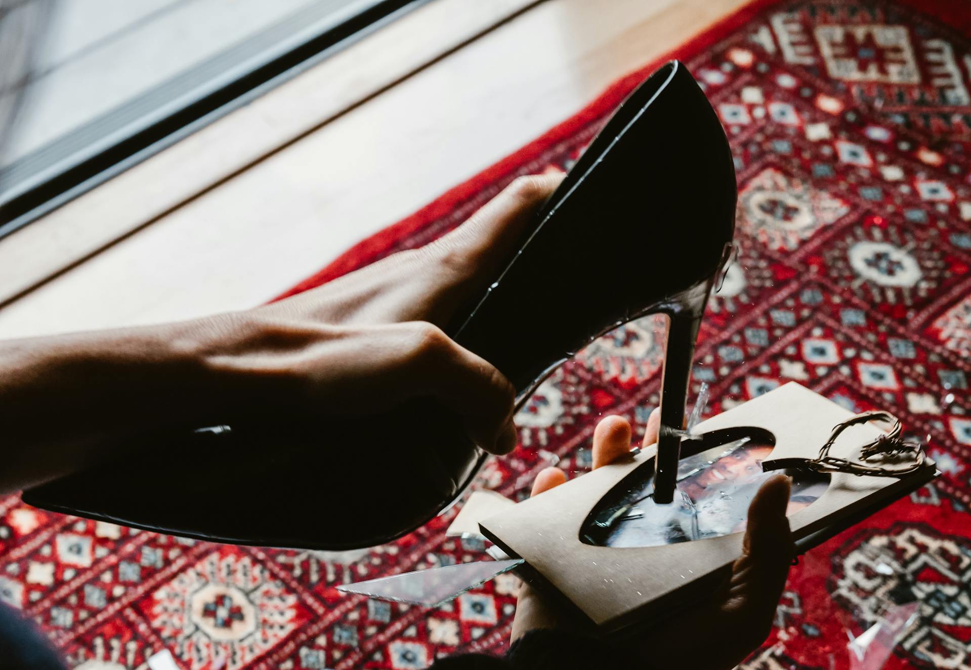 A woman breaking the glass in a picture frame with her shoe | Source: Pexels