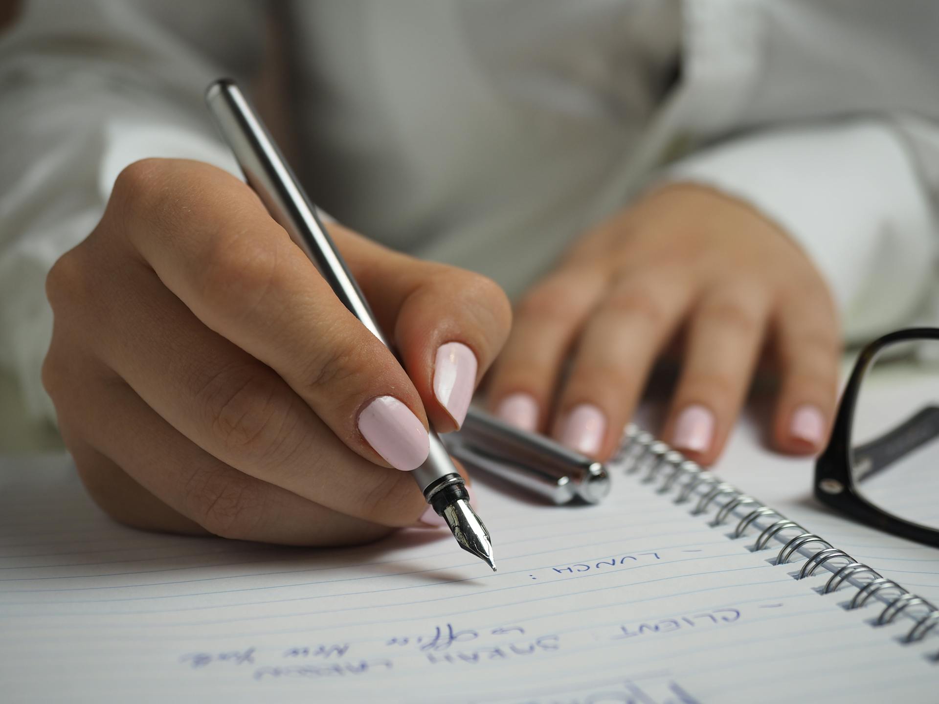 A woman writing on a paper | Source: Pexels