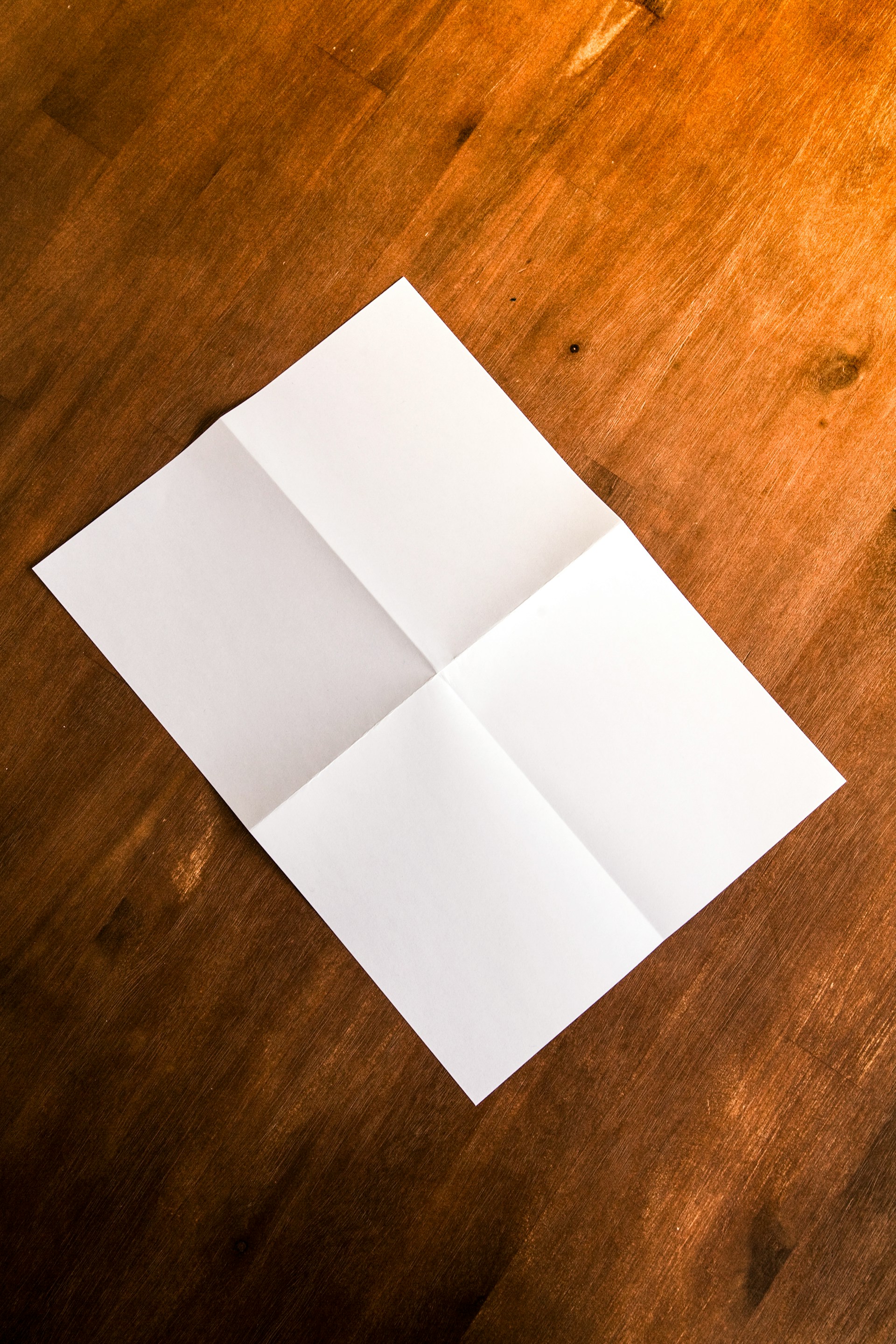 A sheet of paper on a brown wooden surface | Source: Unsplash