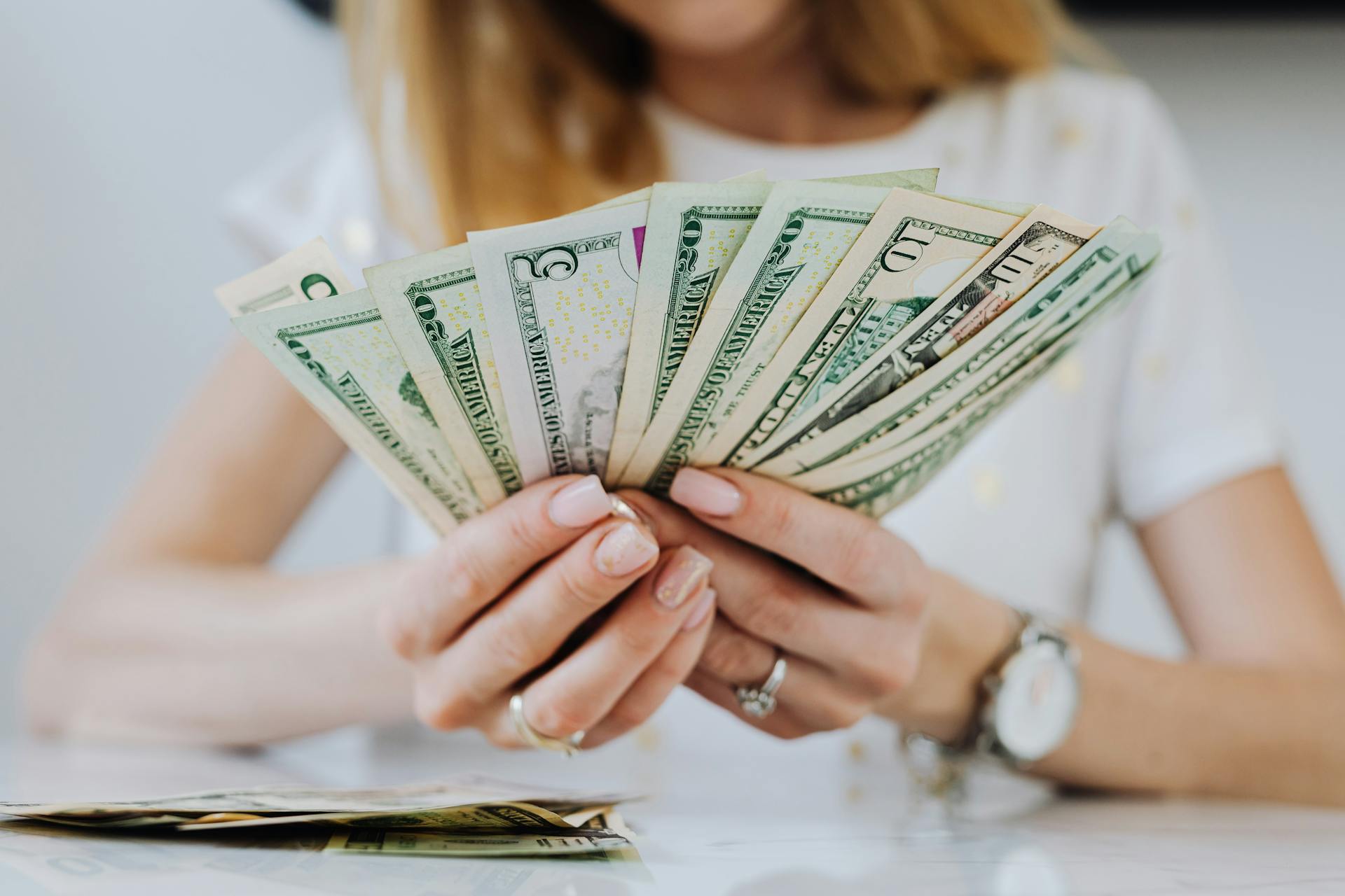 A woman looking at money in her hands | Source: Pexels