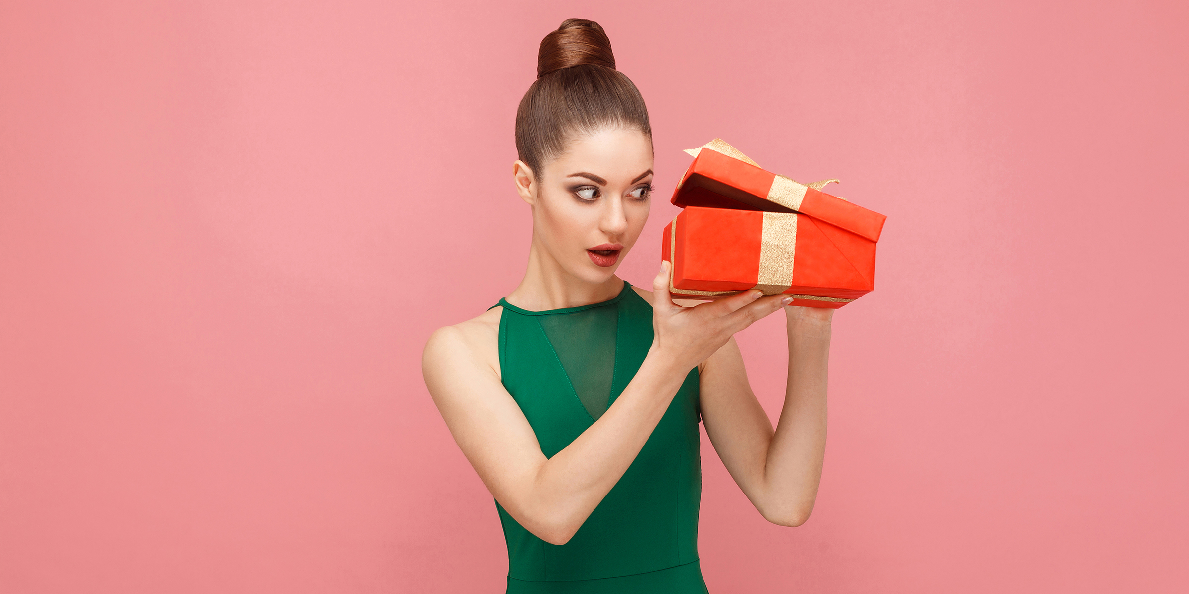 A shocked woman peeking into a gift box | Source: Shutterstock