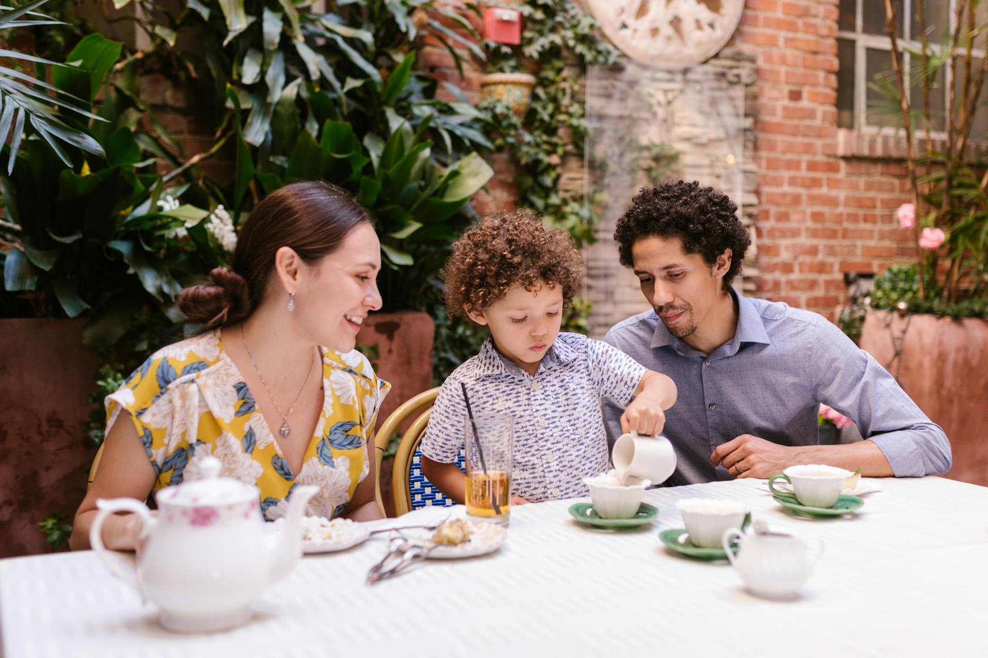 A little boy sitting with his parents | Source: Pexels