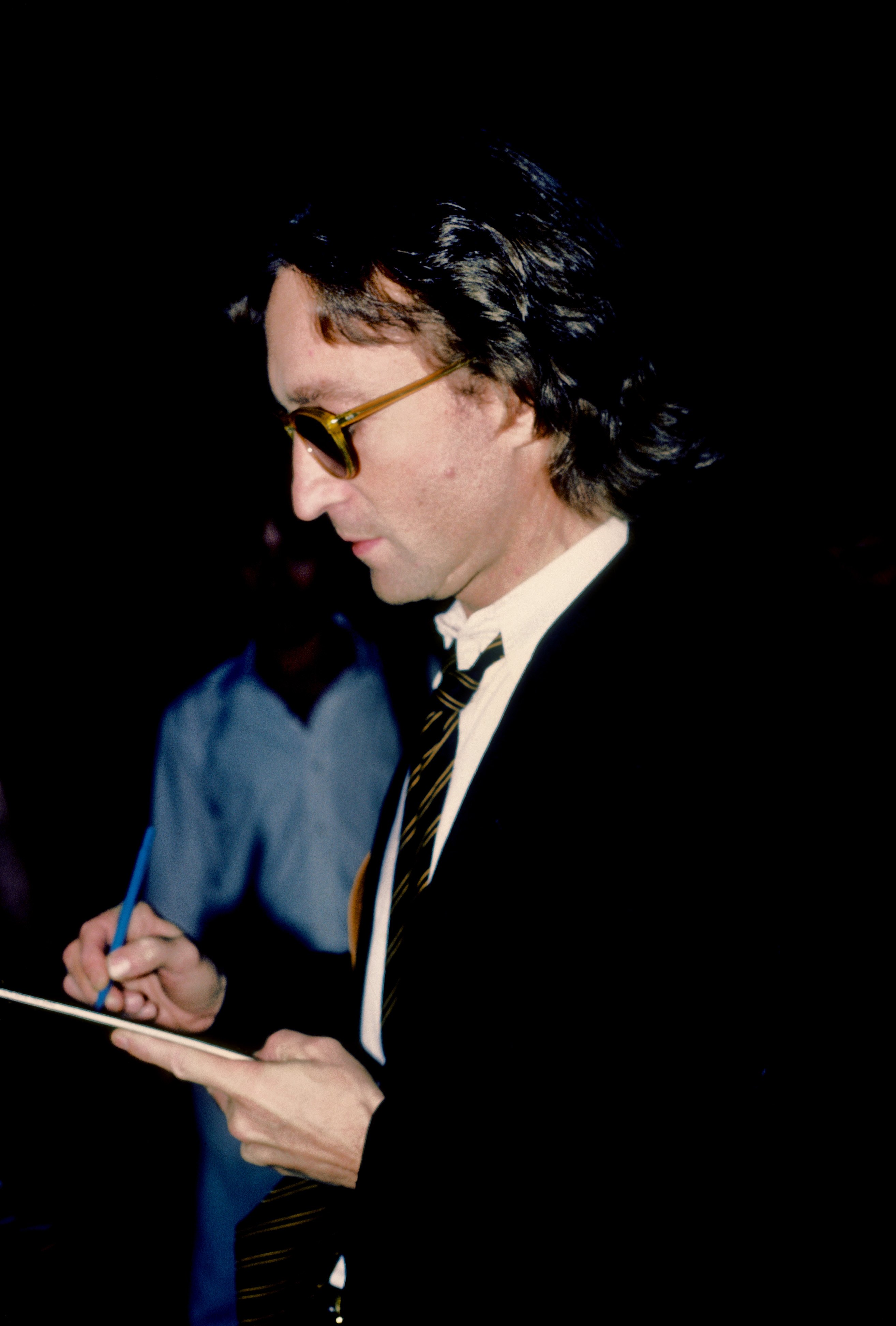 John Lennon signs an autograph outside of the Times Square recording studio The Hit Factory in New York City in August 1980. | Source: Getty Images
