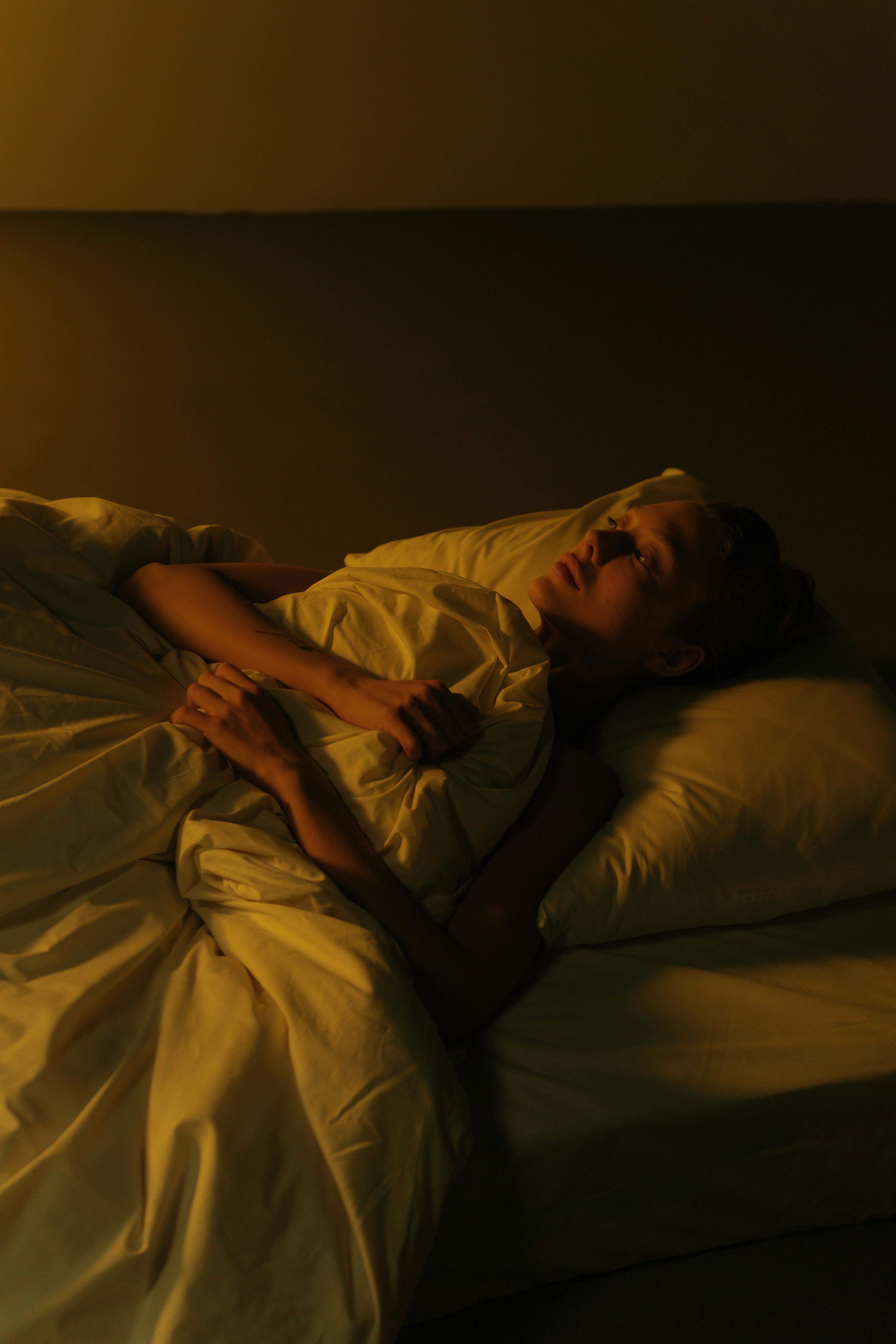 A sad woman lying in bed | Source: Pexels