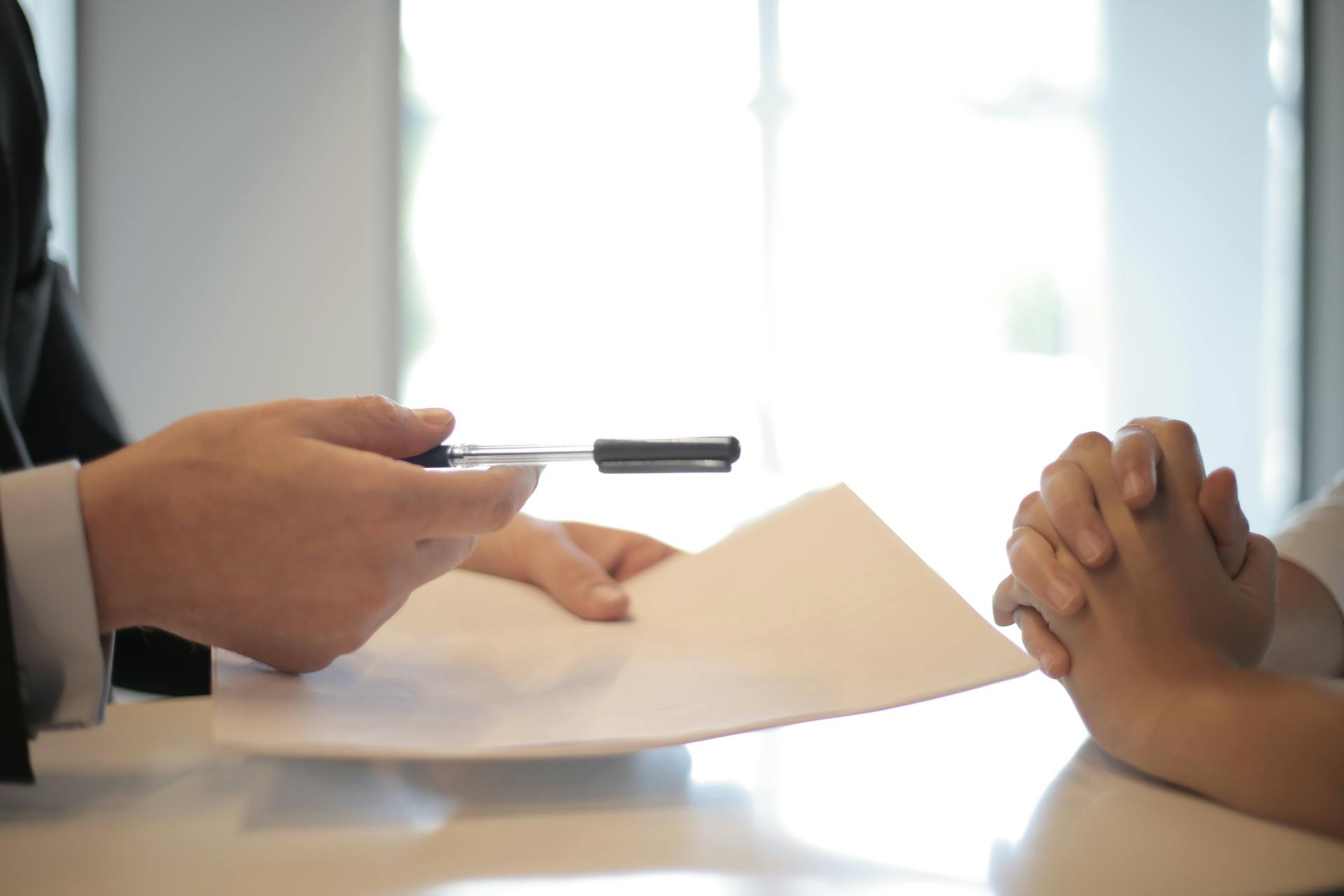 A man asking a woman to sign a document | Source: Pexels