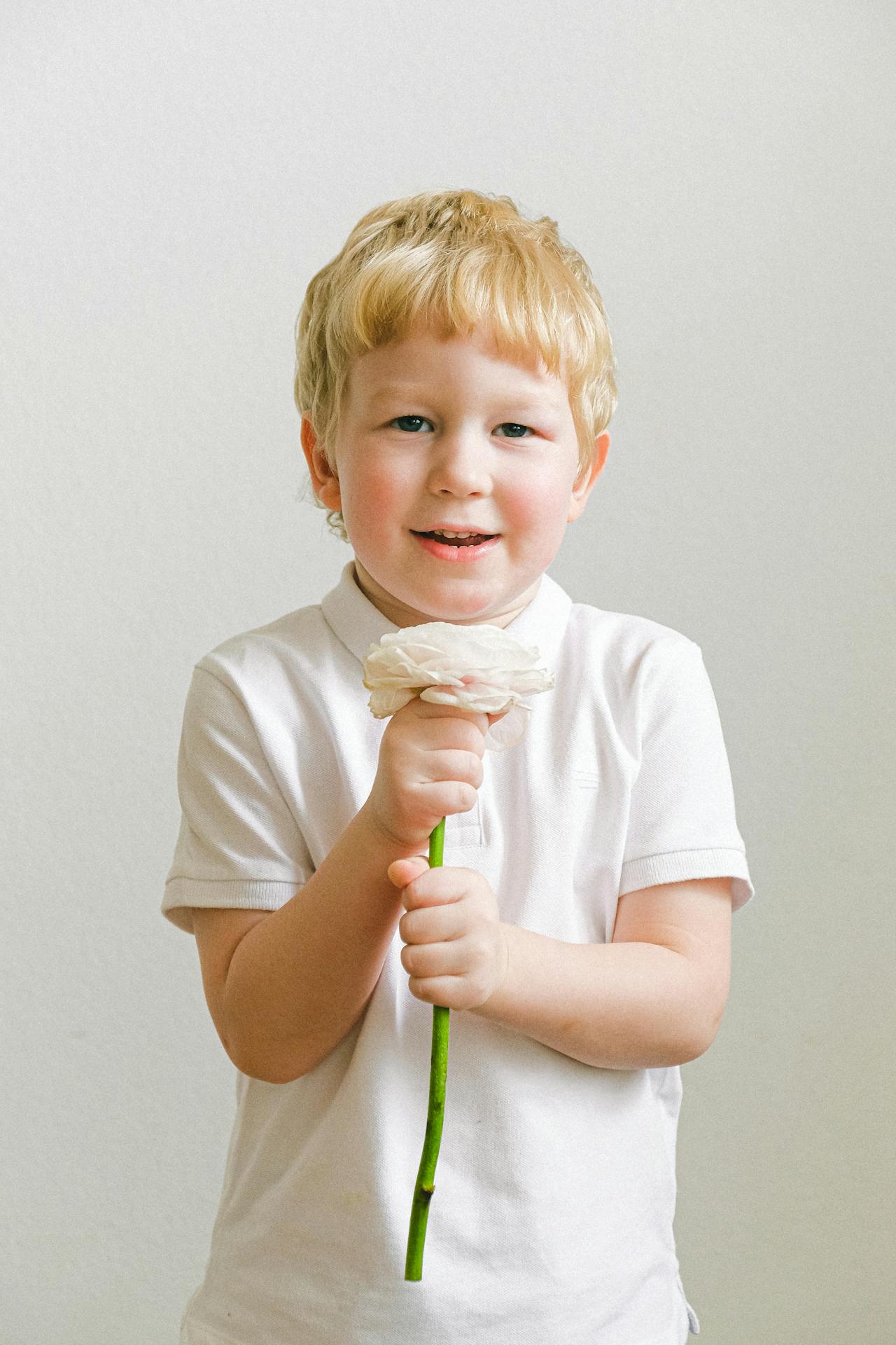 An excited little boy holding a flower | Source: Pexels