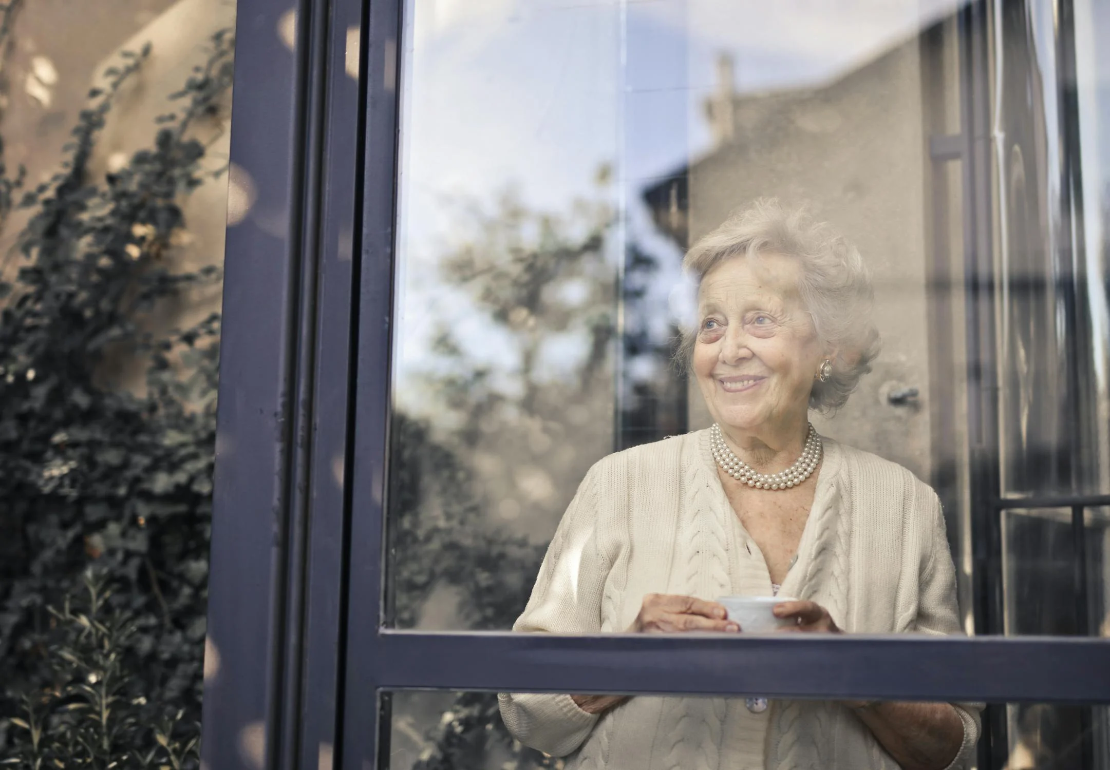 A smiling elderly woman on her porch | Source: Pexels