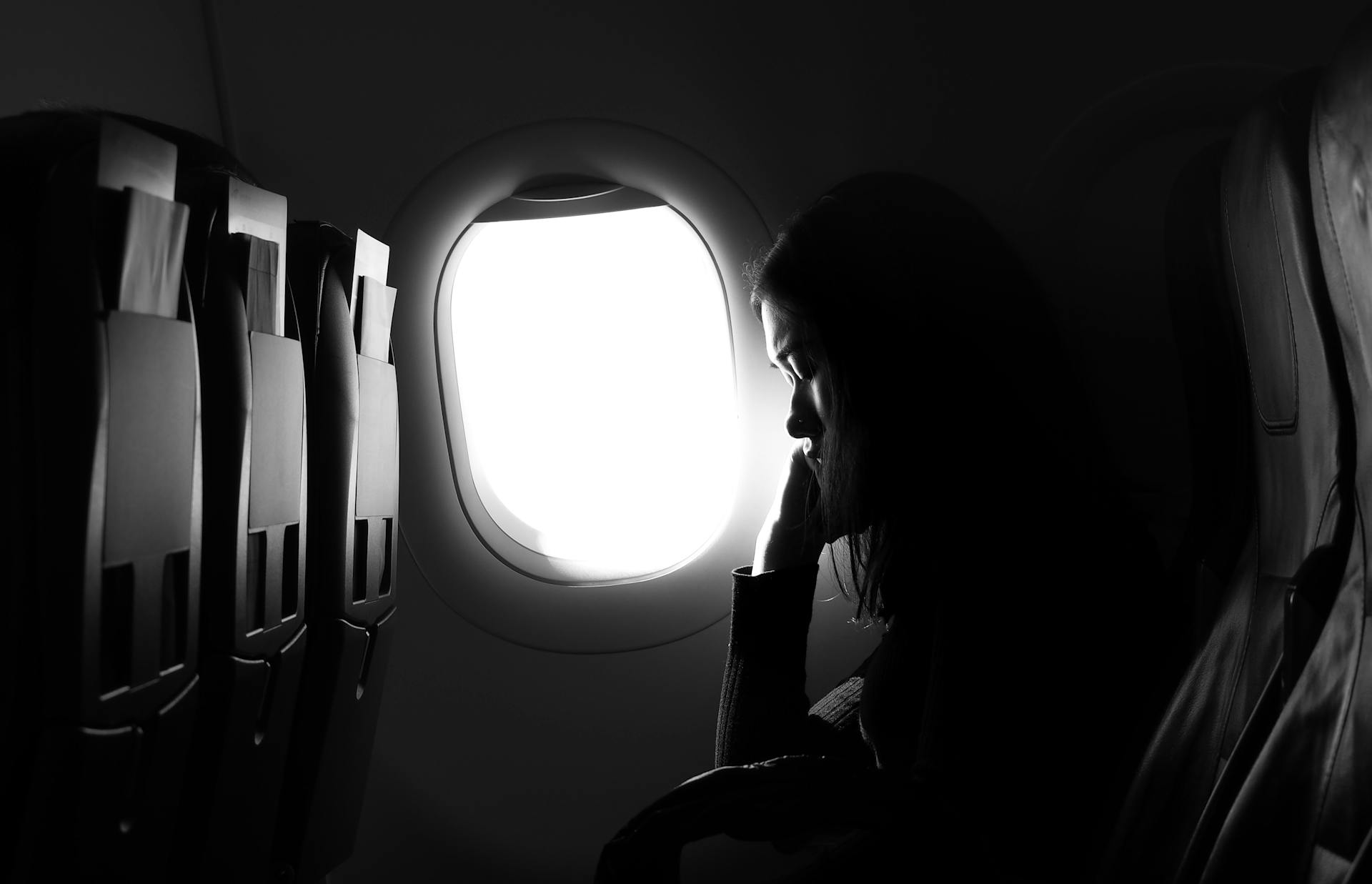 A young woman sitting by window in an airplane | Source: Pexels