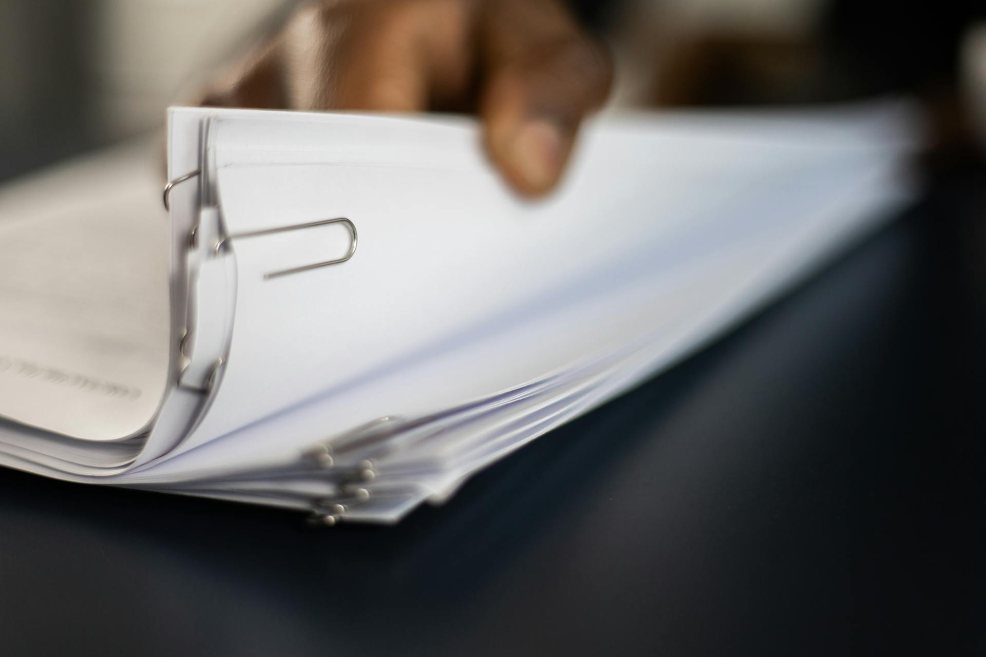 A person holding a stack of pinned documents | Source: Pexels